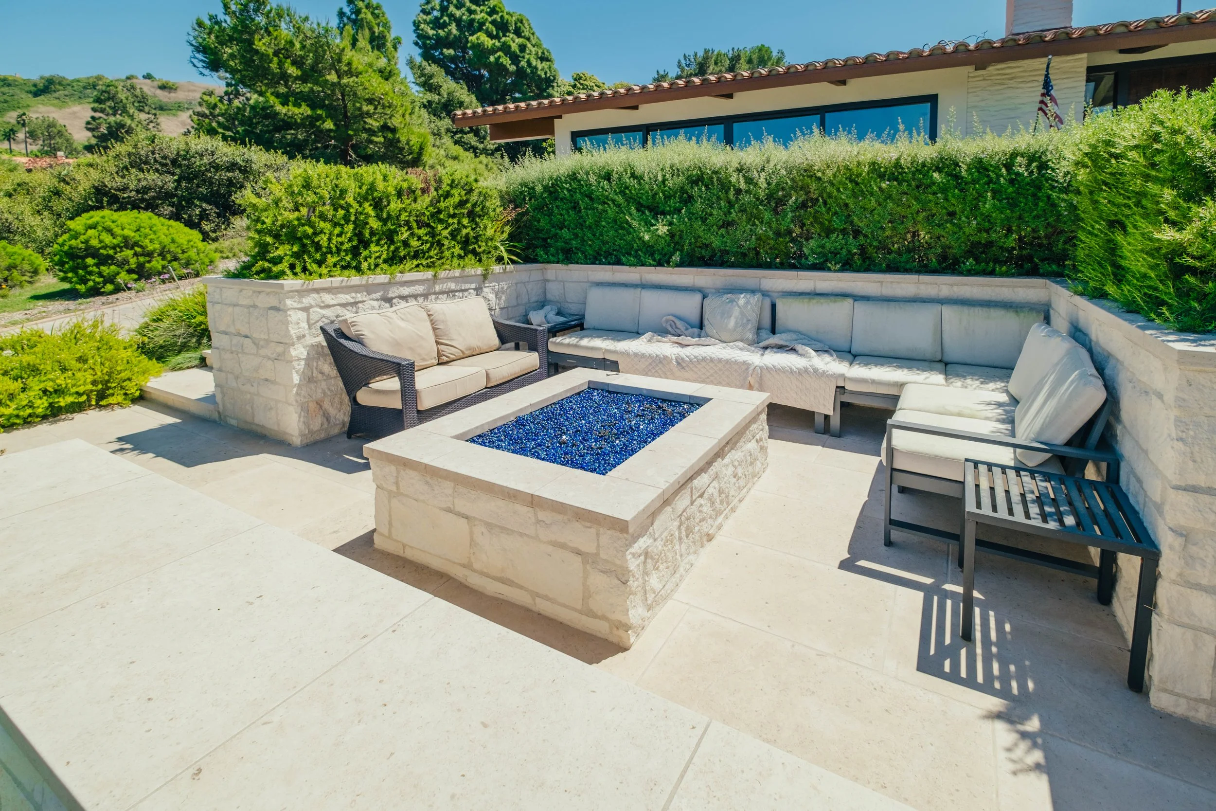Outdoor fire pit and seating area incorporated into a residential backyard by Rosewood Landscape