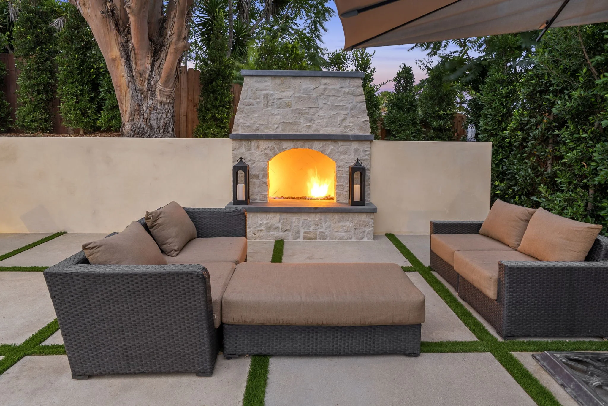 Custom outdoor fireplace and patio seating area by Rosewood Landscape