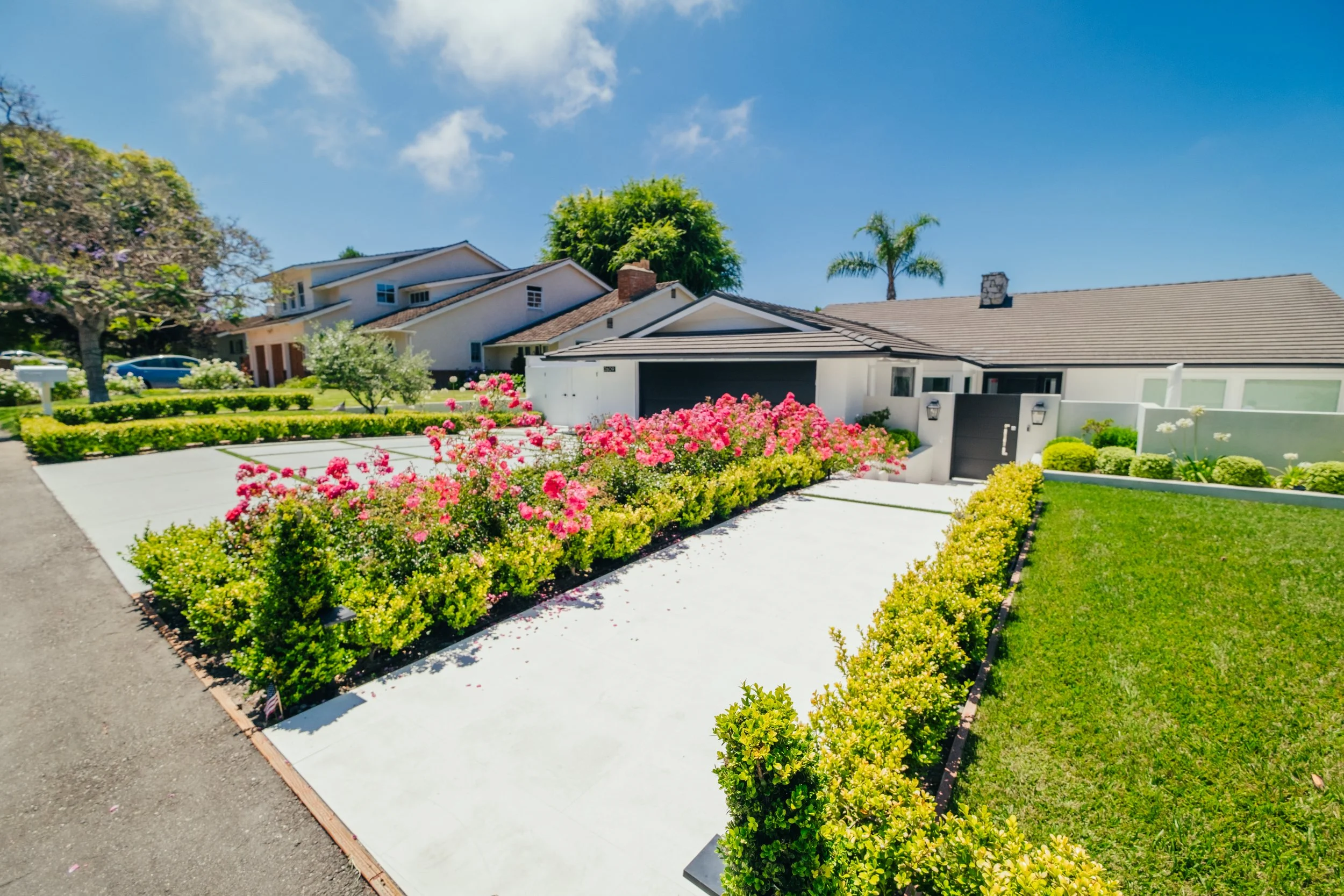 Front yard landscape design with flowering gardens and manicured lawn by Rosewood Landscape