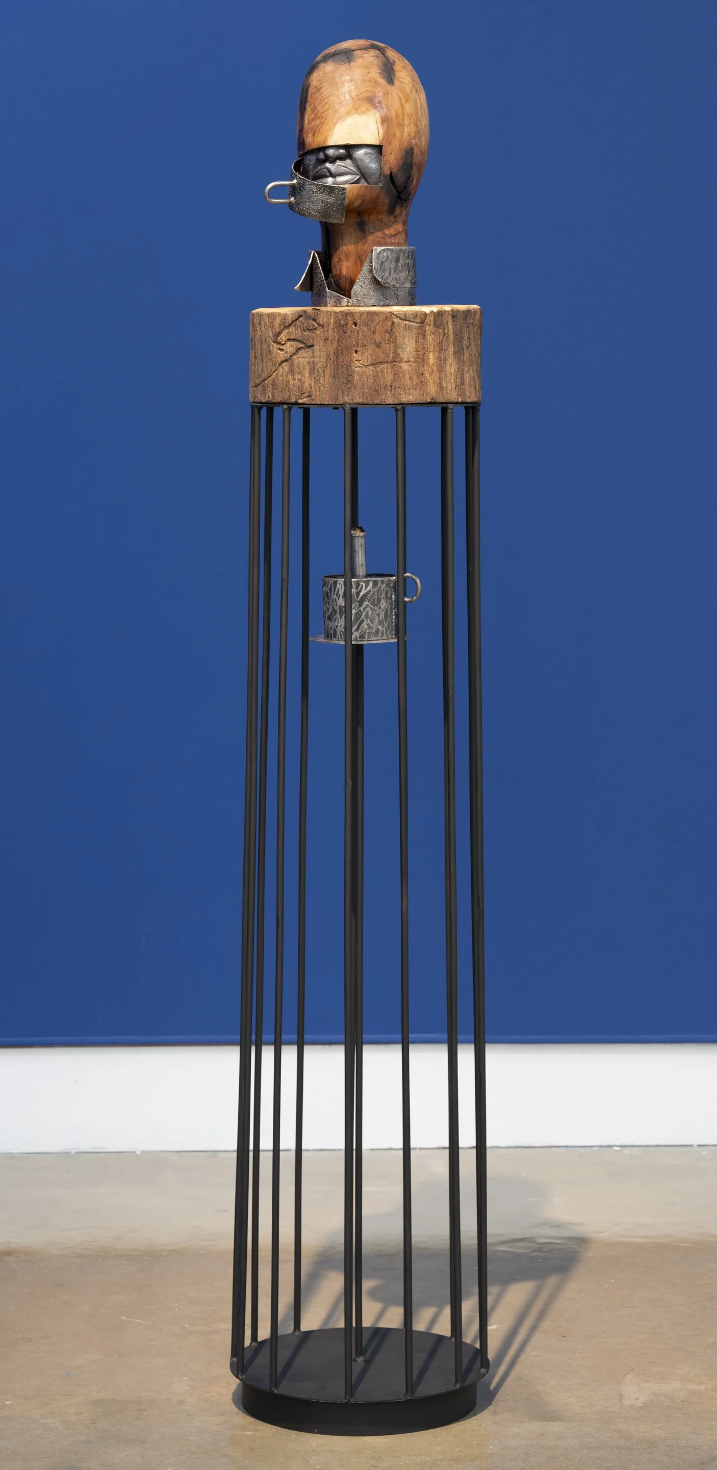 Death Within
2024
Sculpture
Wood & metal
13.8" × 13.8" × 71"

This piece is a compelling fusion of abstraction and realism of a male figurative sculpture. The work explores the psychological and emotional effects of oppression and repression, embodyi