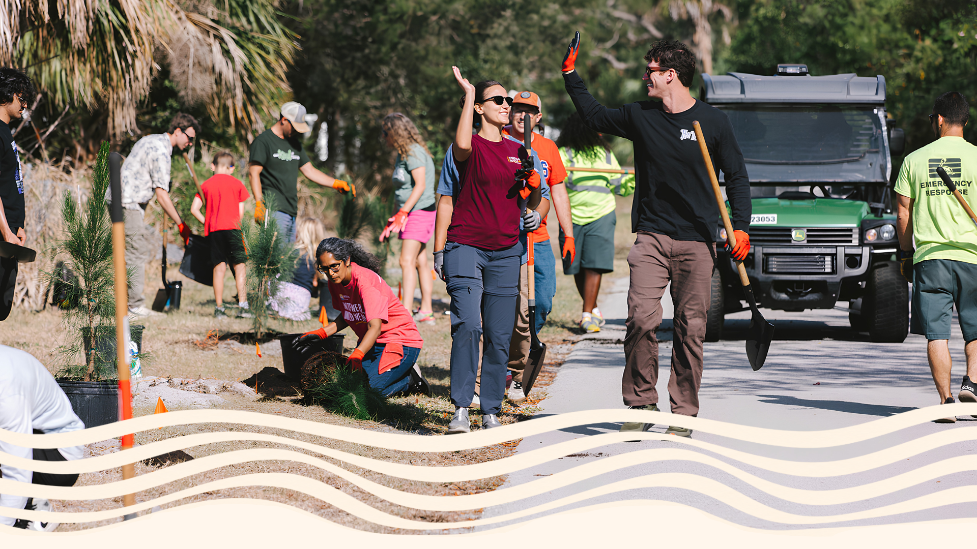 Group of people planting trees and cleaning up in a park, some holding shovels and young trees, others planting or watering.