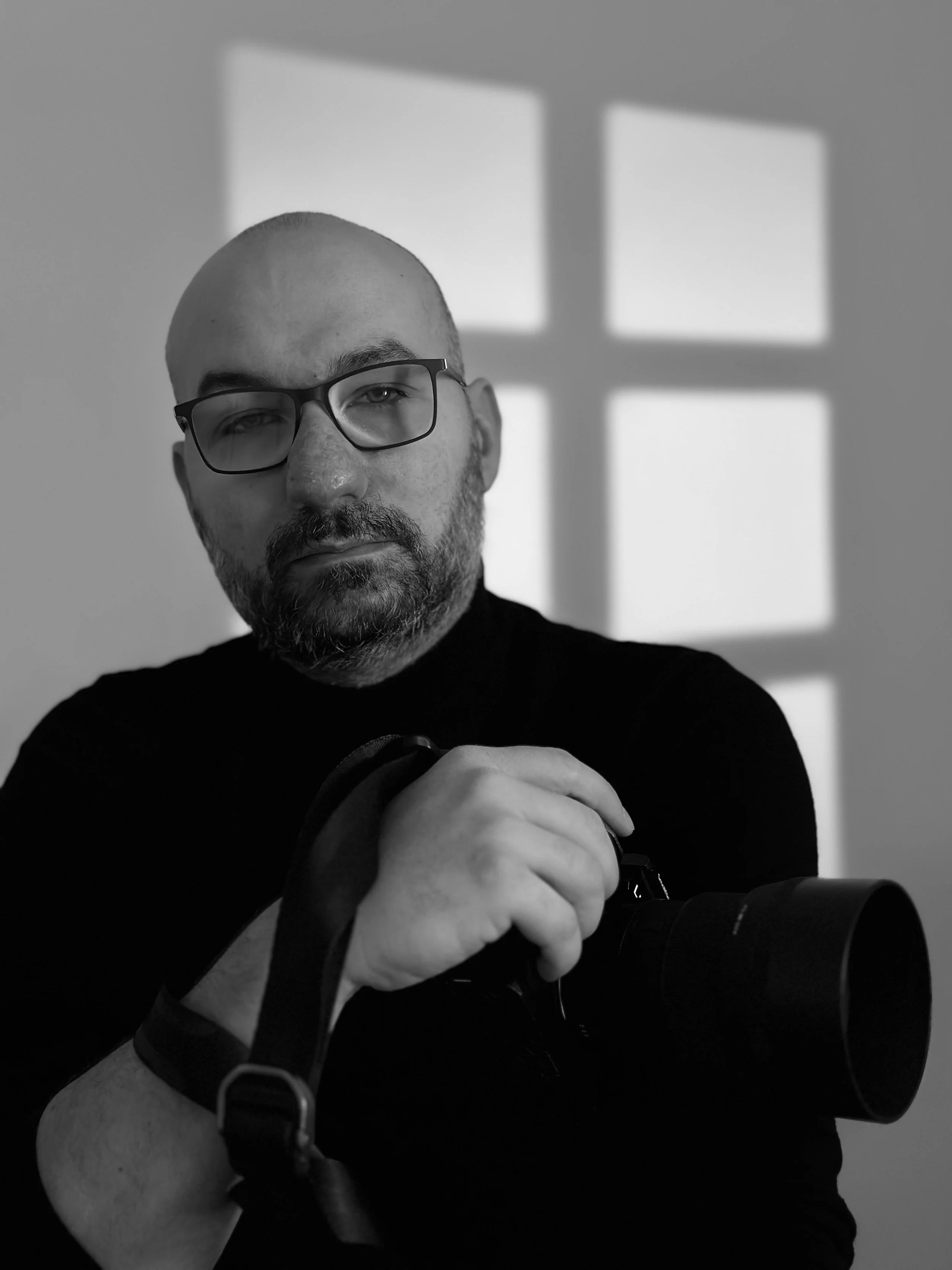 Alexandru Prepeliță, Fotograf in Österreich, mit Kamera im Schwarz-Weiß-Porträt