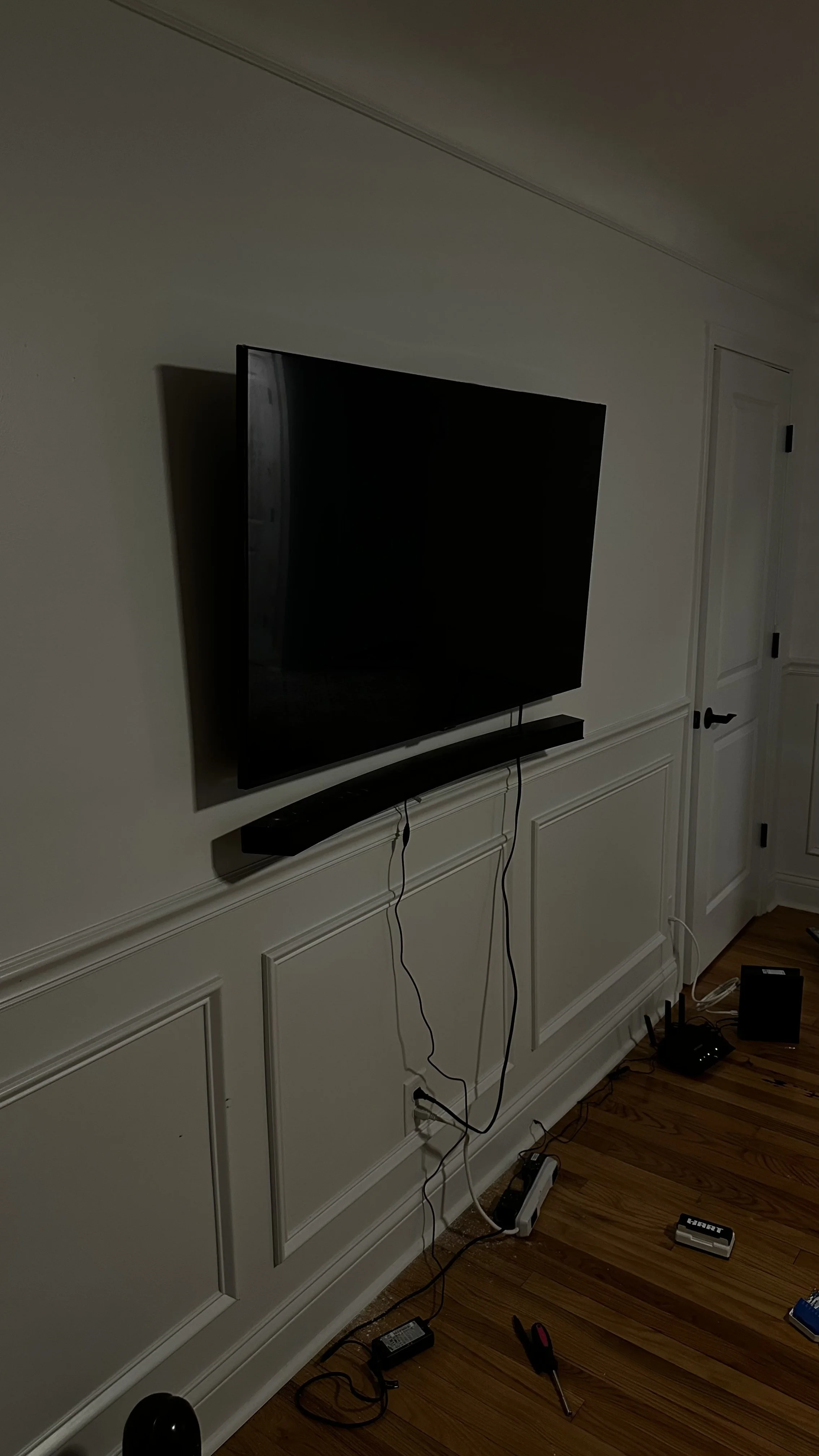 Flat-screen TV wall-mounted with a soundbar installed directly below it.