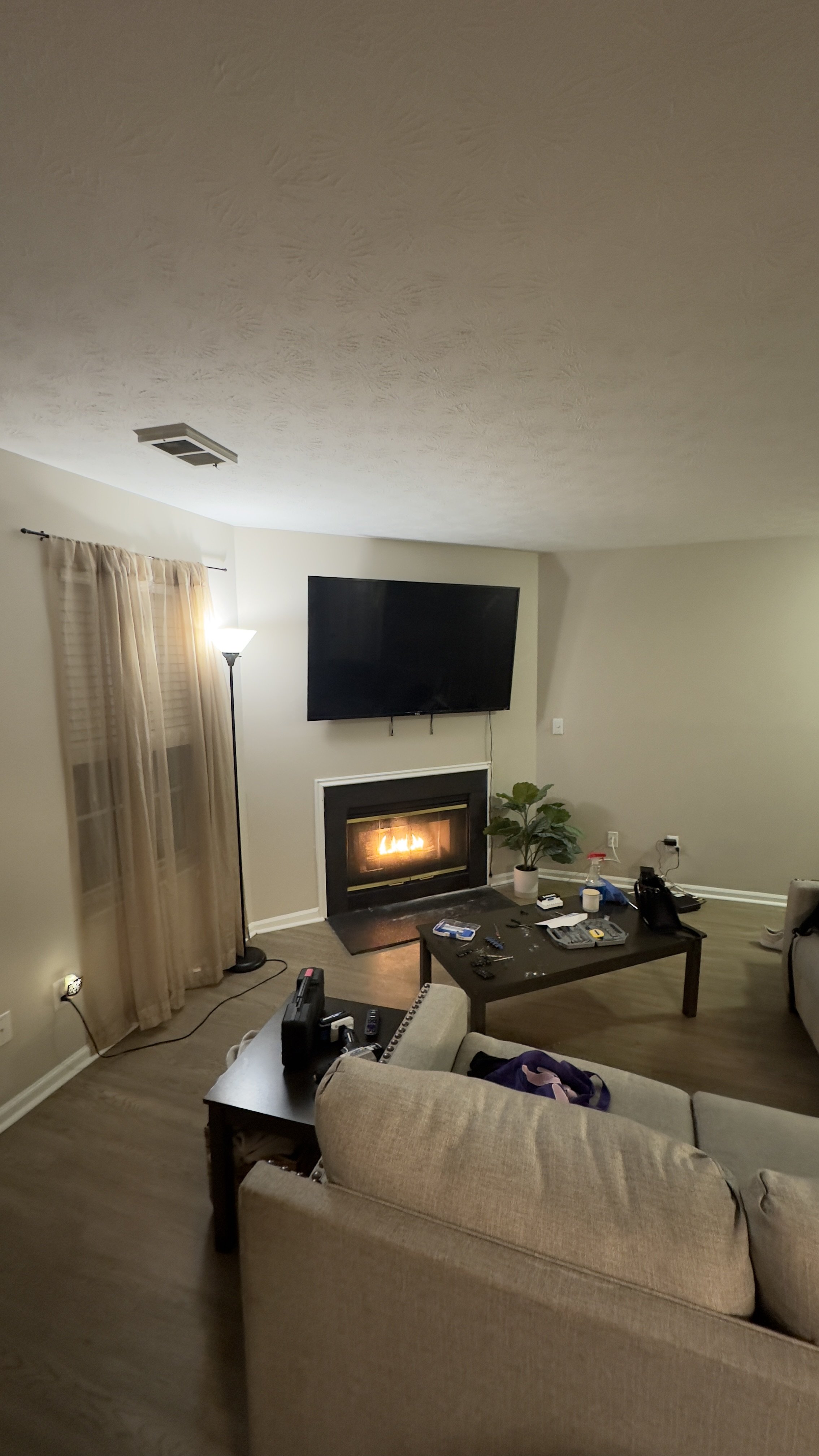 Wall-mounted TV installed in a residential living room above a fireplace.