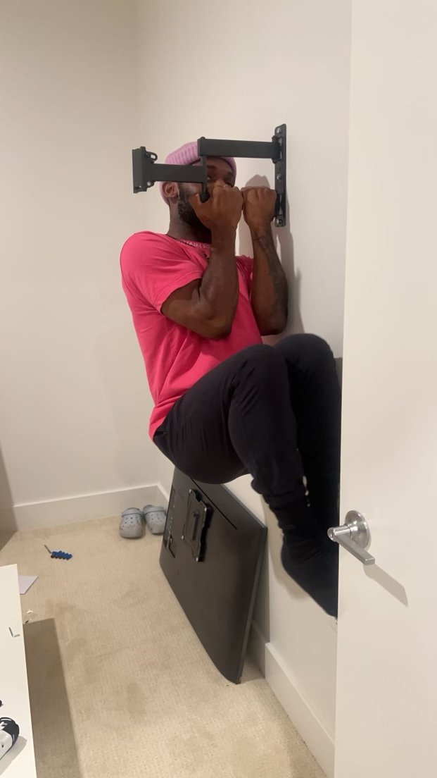 Full-motion TV wall mount being load-tested to confirm a secure installation.
