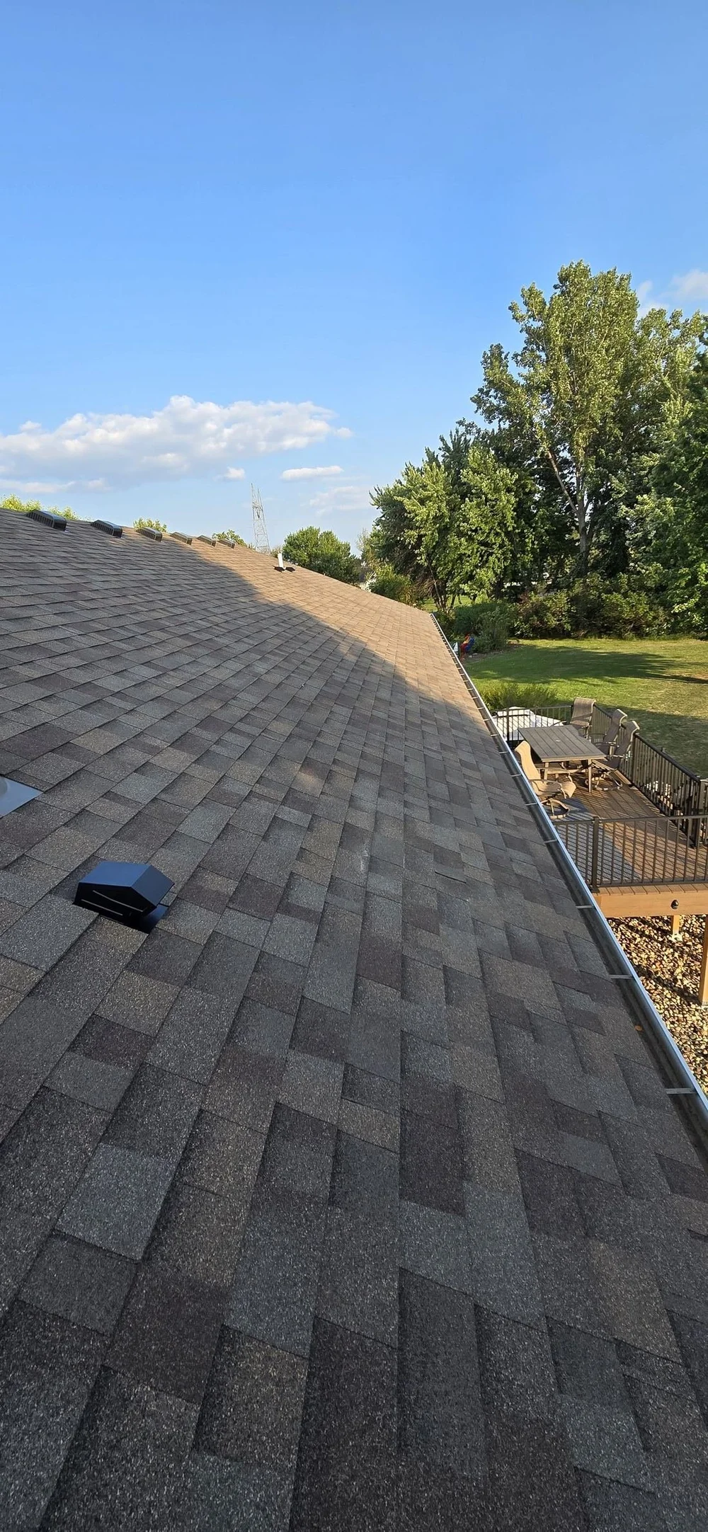 Residential roof replacement overlooking a backyard deck in Sioux Falls, South Dakota