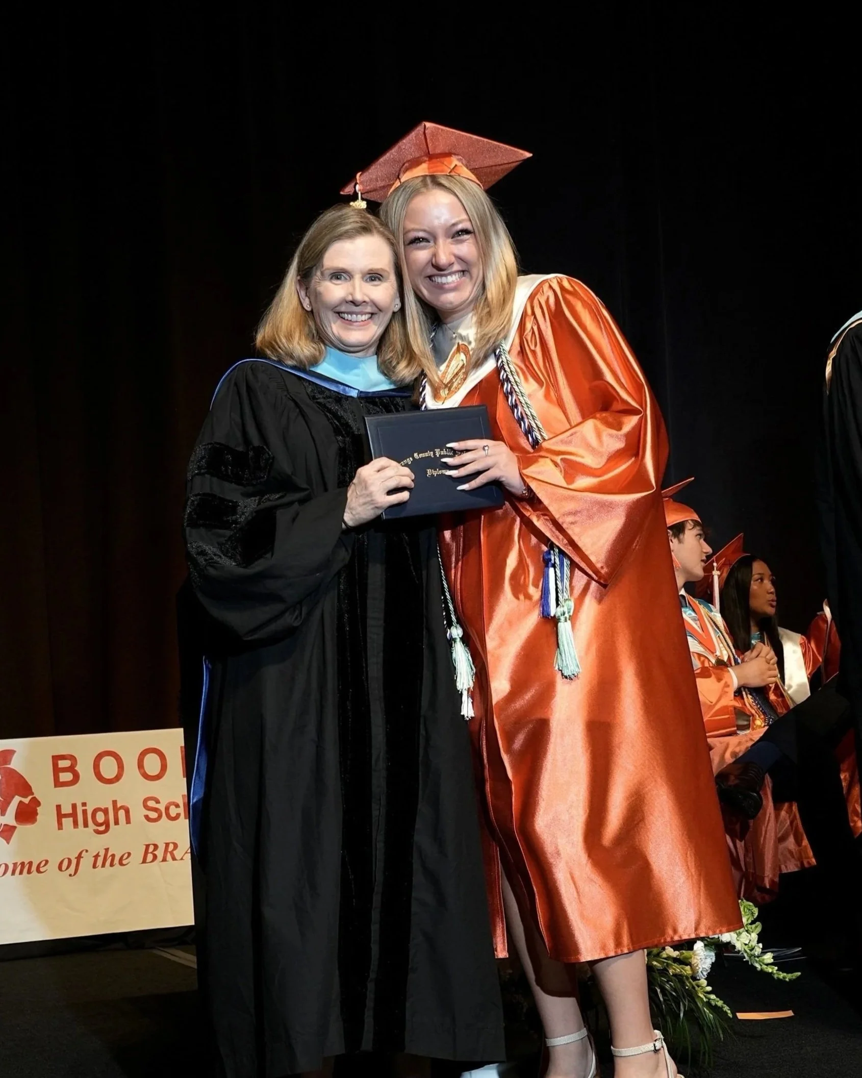 Glenda Hammons, Ed.D., presenting a diploma to a graduate at a Boone High School commencement ceremony in Orlando, Florida