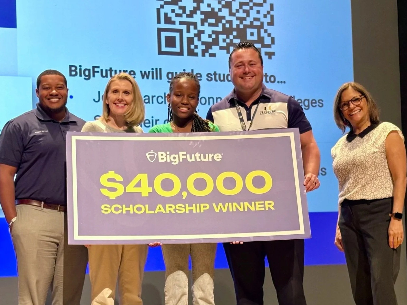 Glenda Hammons, Ed.D., celebrating a University High School student’s $40,000 College Board BigFuture scholarship on stage with the school’s principal and program leaders in Orlando, FL