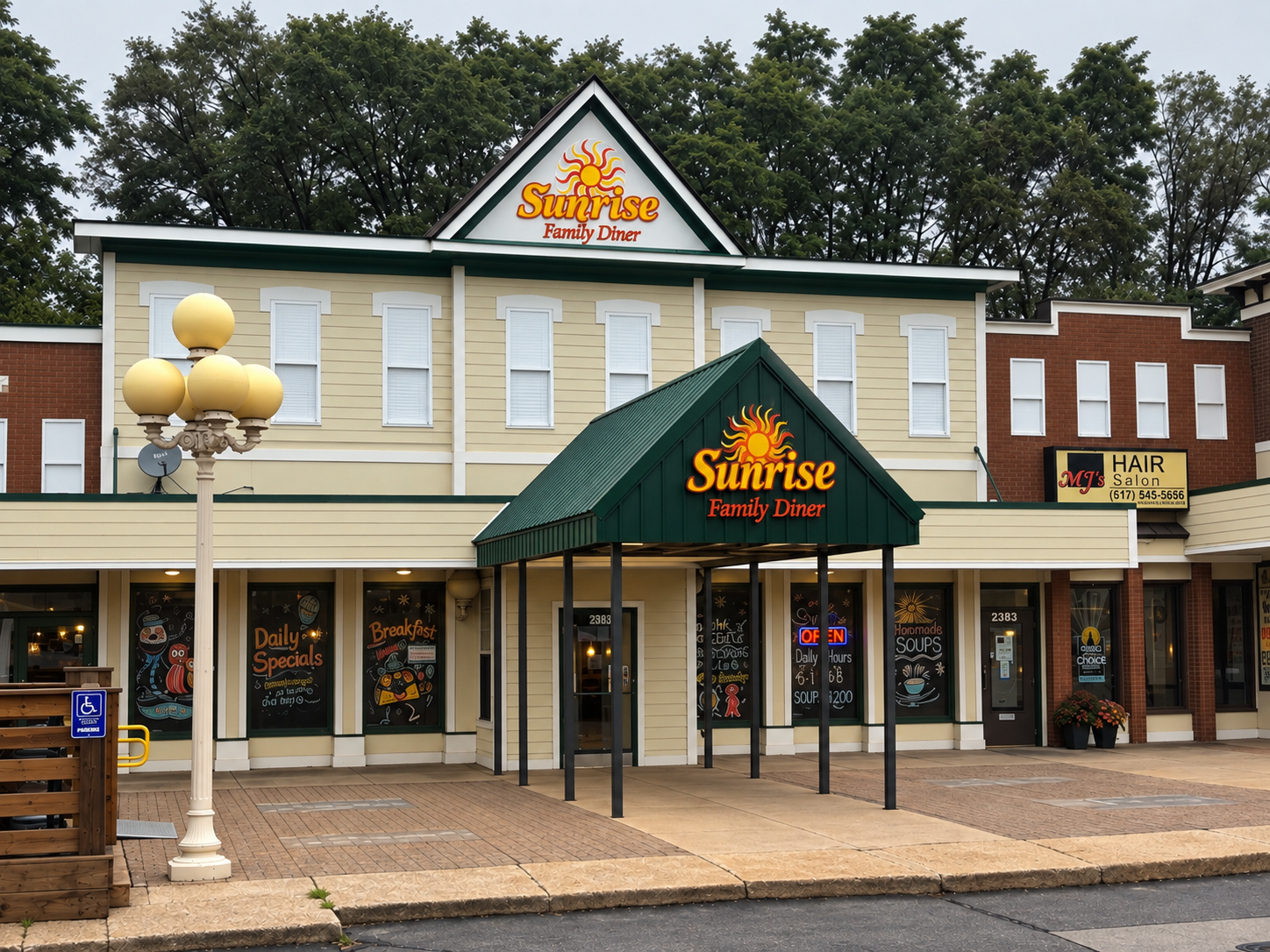 A two-story building with a sign that says 'Sunrise Family Diner' and decorative signs advertising daily specials and breakfast. The building has beige siding, white accents, and a green roofed entrance porch with an illuminated 'Open' sign. There's a street lamp, a handicap parking sign, and trees in the background.