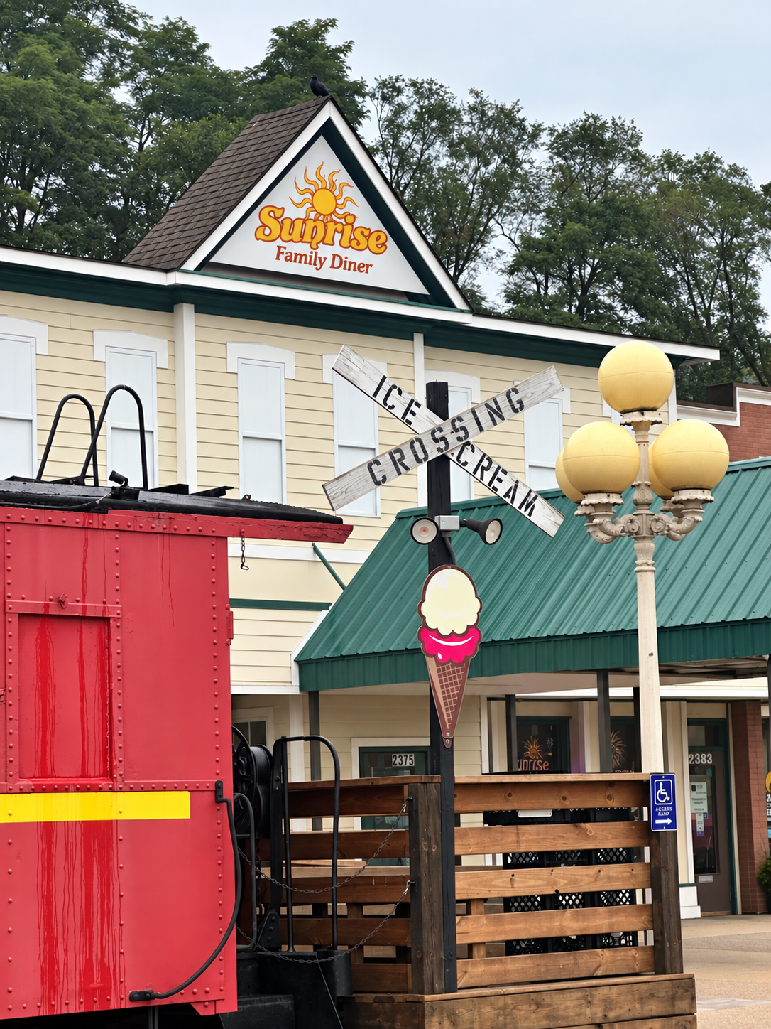 Exterior of Sunrise Family Diner with ice cross and cream sign, ice cream cone decoration, and trees in the background.