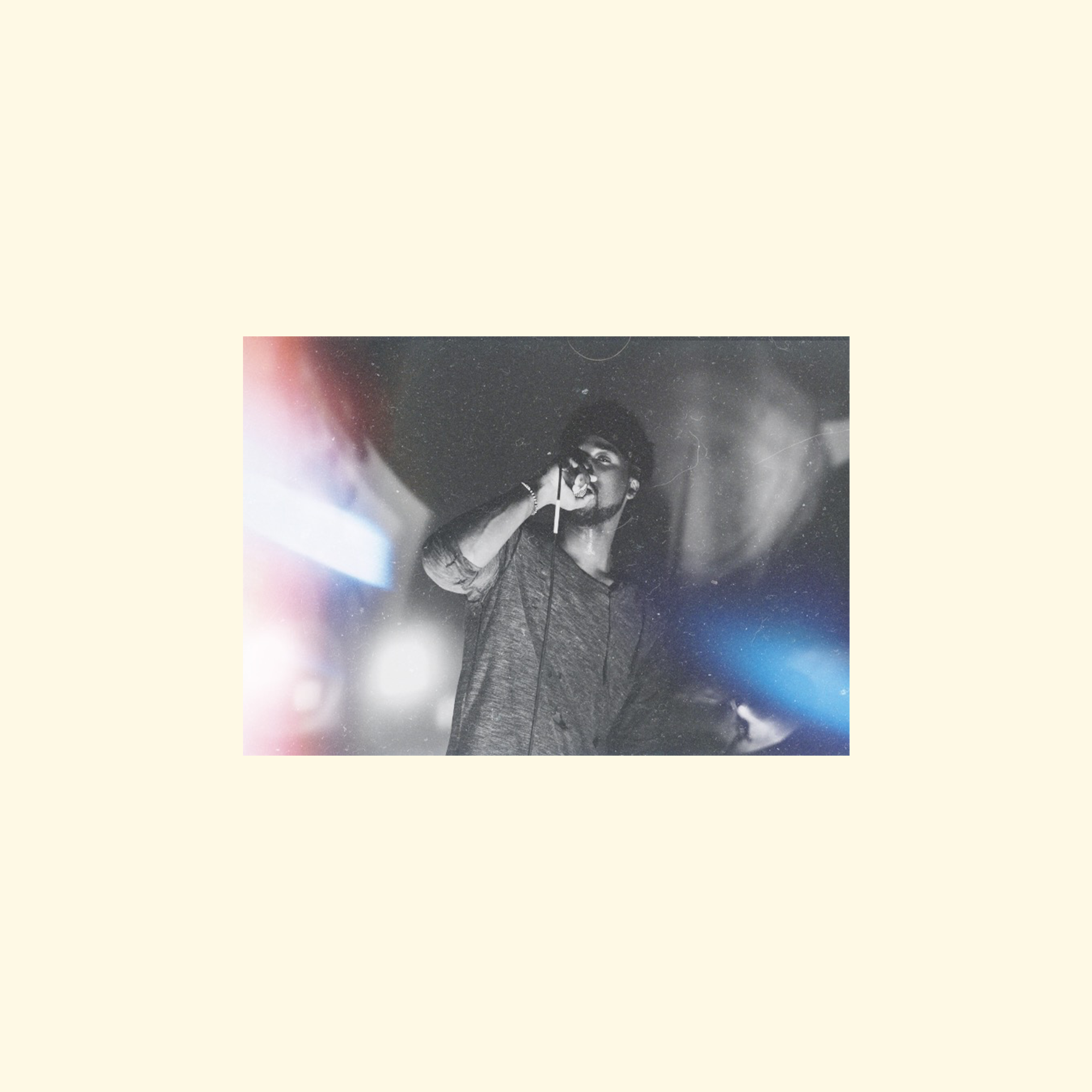 Black and white photo of a woman singing into a microphone on stage, with cosmic background