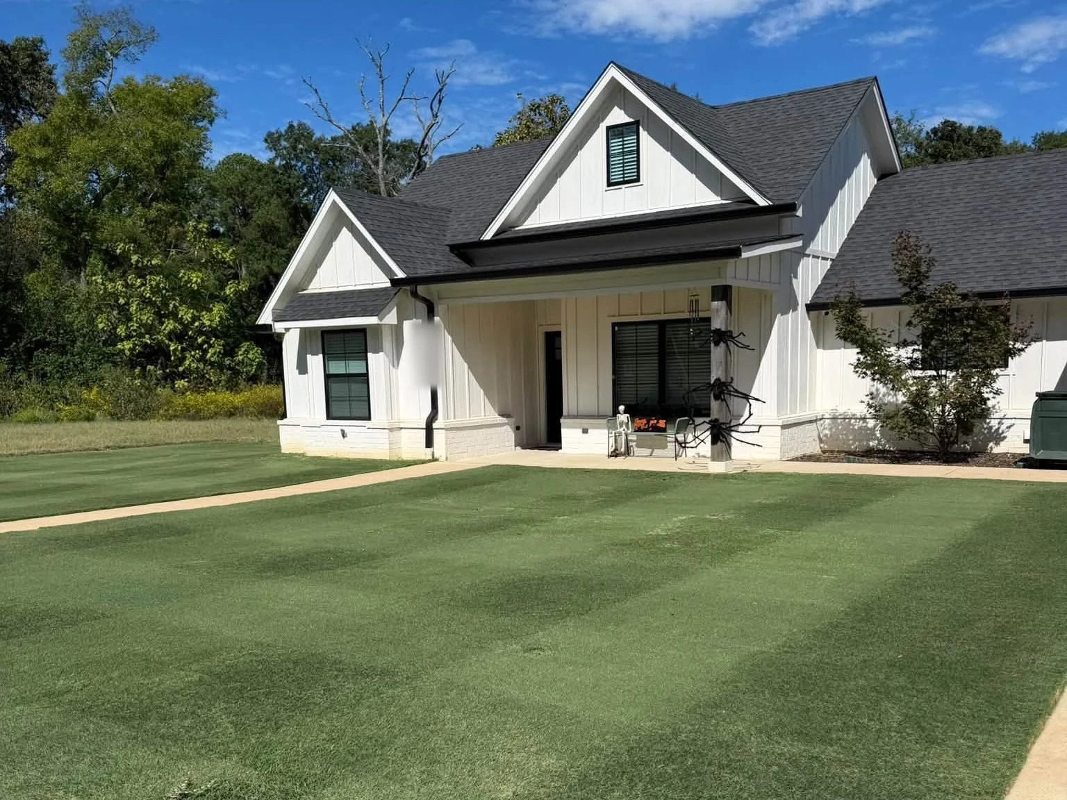 Derek's striped front lawn and white farmhouse