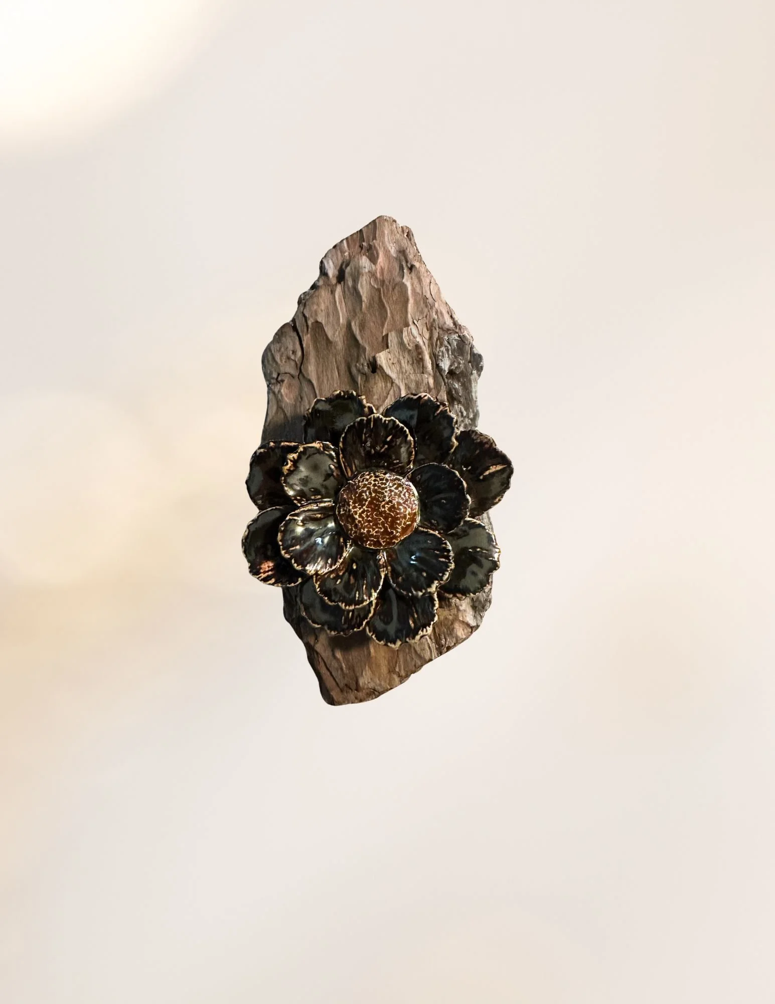 A wooden piece with decorative black and gold flowers attached to it.