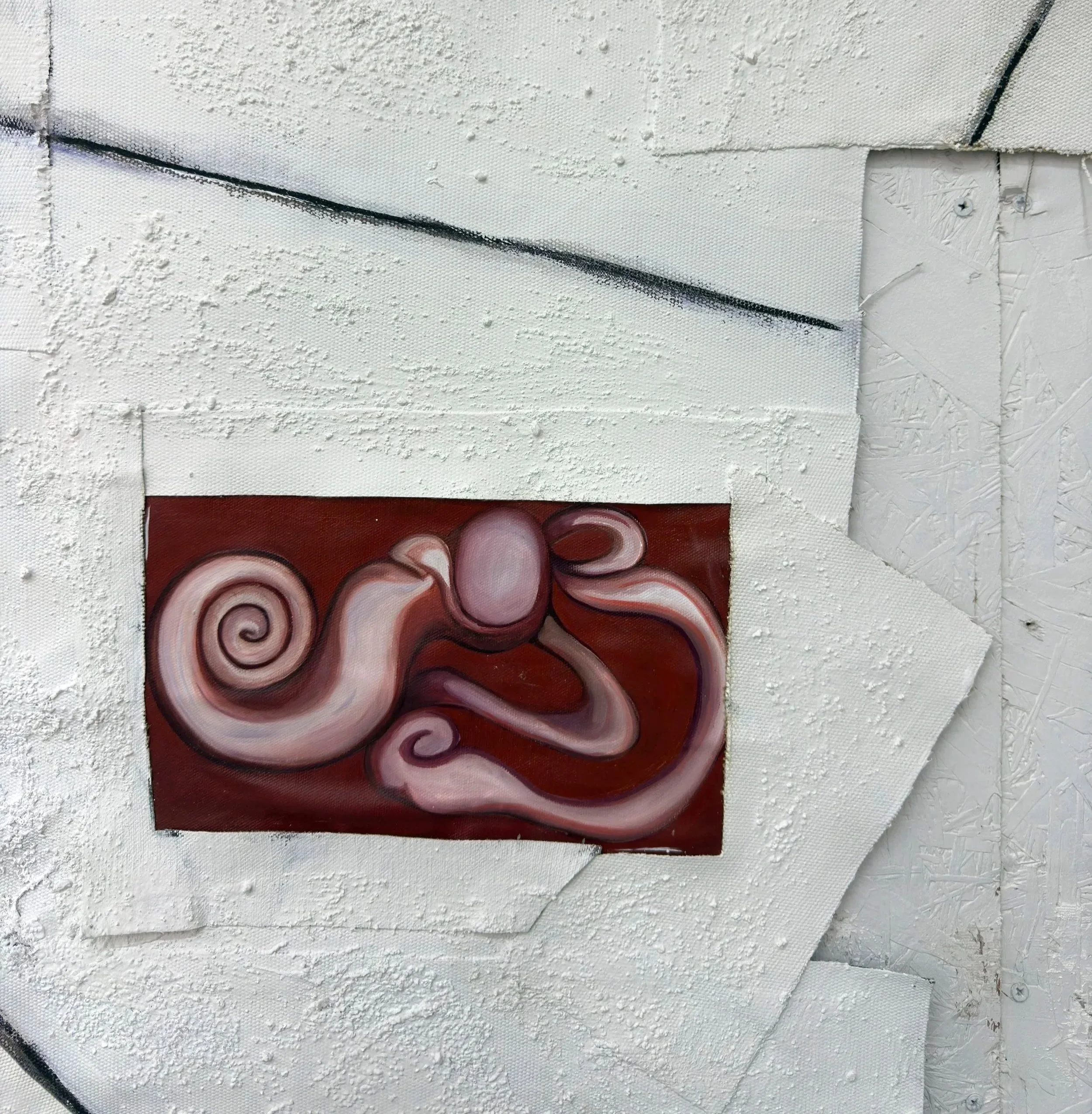 Lienzo con diseño abstracto de círculos en tonos rojos, blancos y negros, rodeado de estuco blanco en una pared y con cinta adhesiva en los bordes.