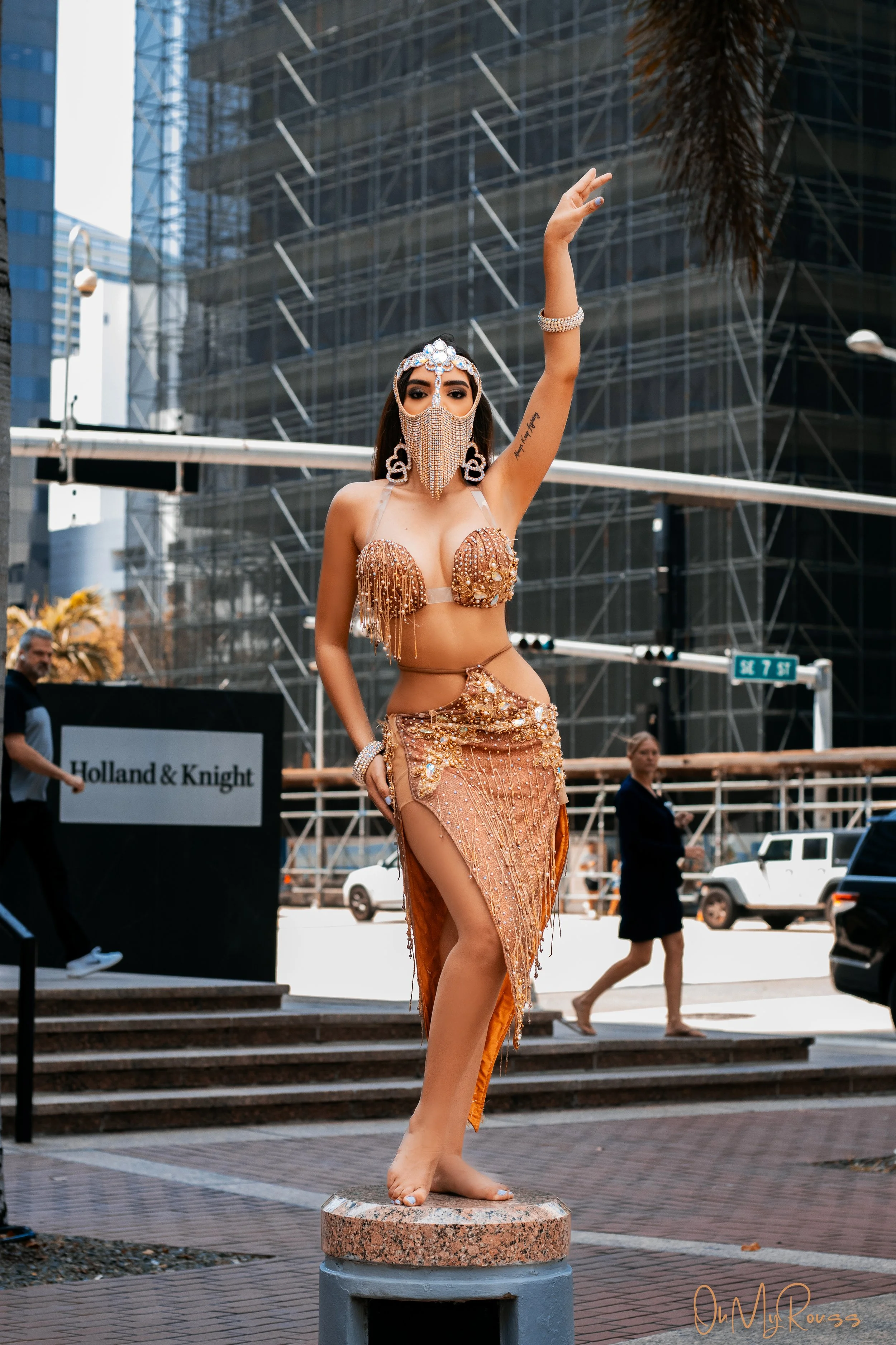 Professional Miami bellydancer Isabella Damiani photographed in a gold embellished costume during an outdoor event.