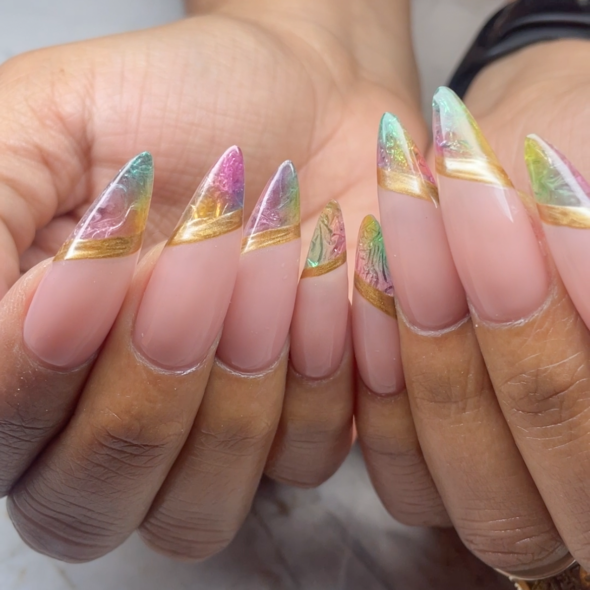 Close-up of hands with long, decorated nails featuring a colorful marble design with pink, green, white, and gold accents.