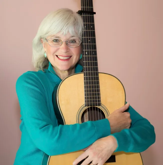 Susan Hugs guitar.webp