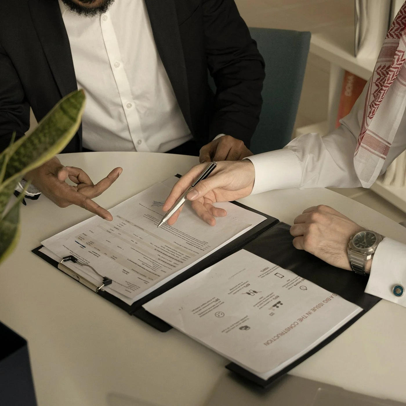 Business professionals reviewing and signing documents at a meeting table