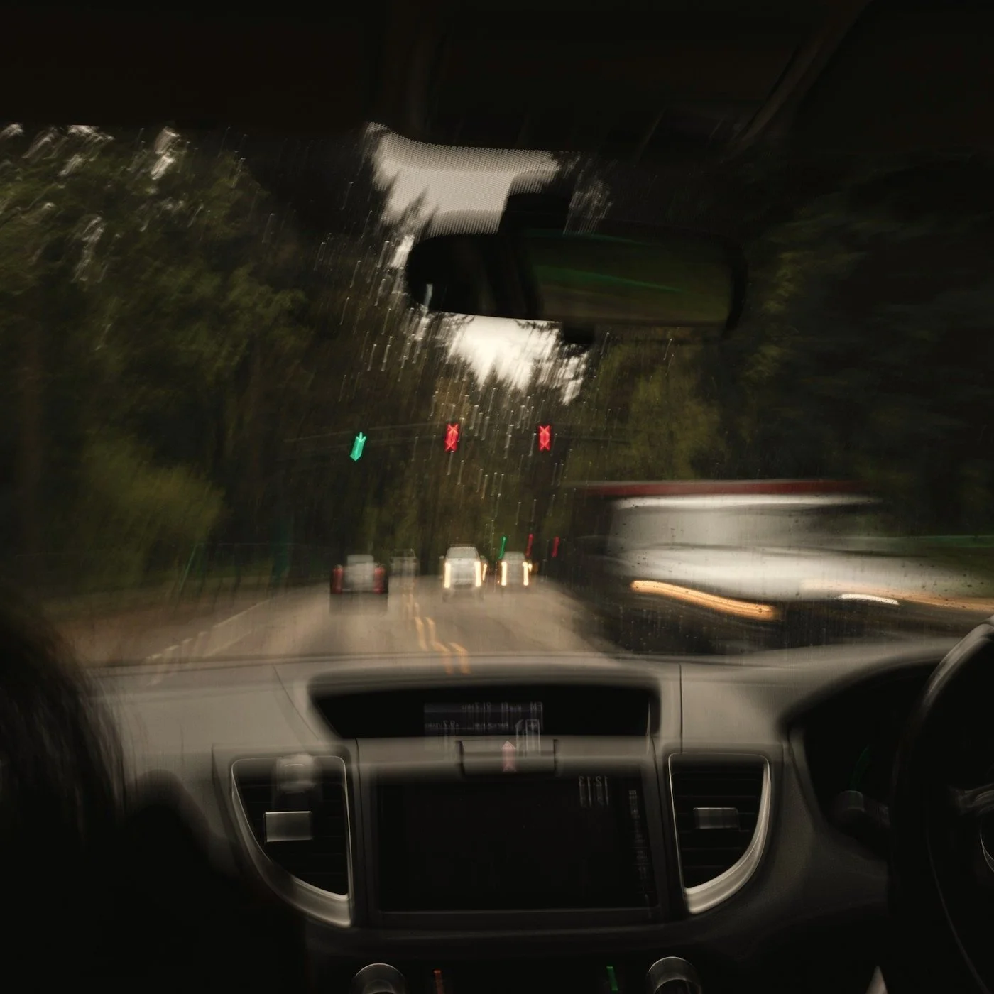 Blurry rainy nighttime view from inside a car approaching a tunnel entrance