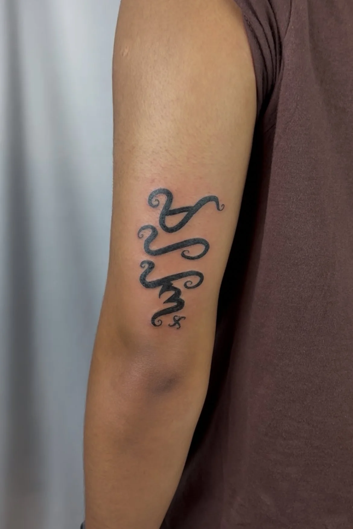 A person's upper arm with a tattoo of the word 'hope' in black cursive script.