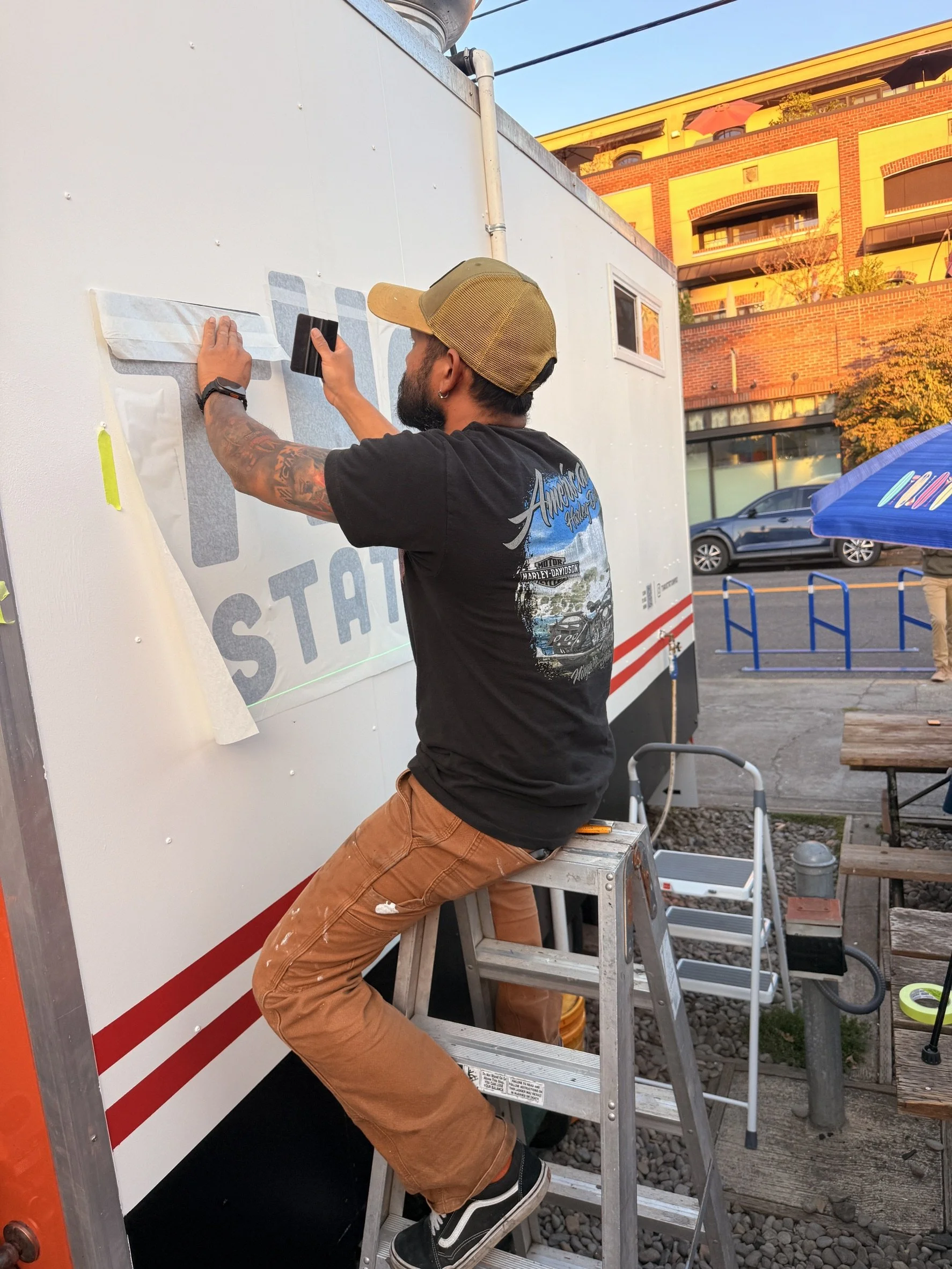 Behind the scenes at Thai Station PDX as our team installs custom vinyl graphics on our Thai food cart in Sellwood, Portland, preparing for our grand opening.