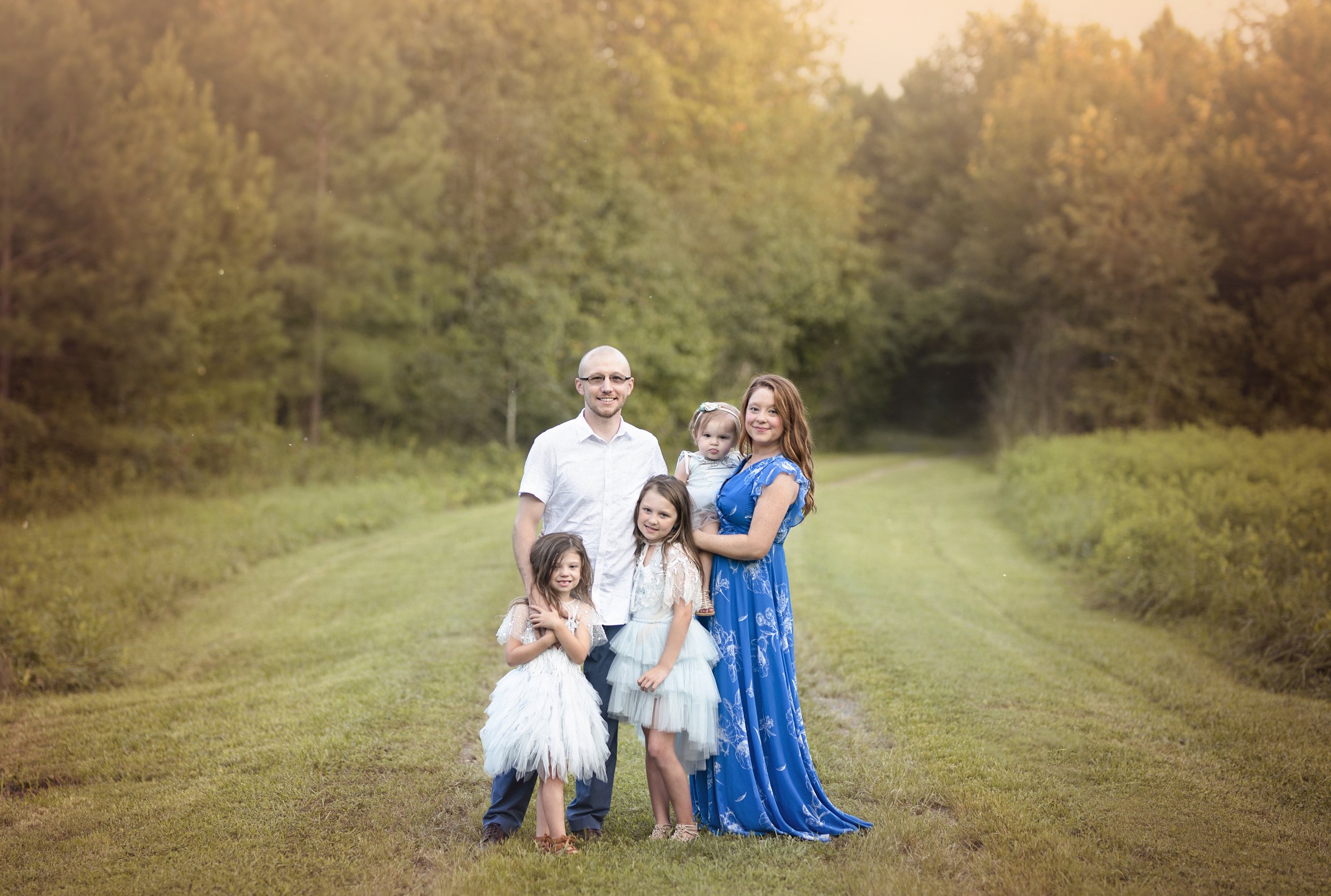 Mary Purdy with her husband and three daughters during an outdoor family portrait session.