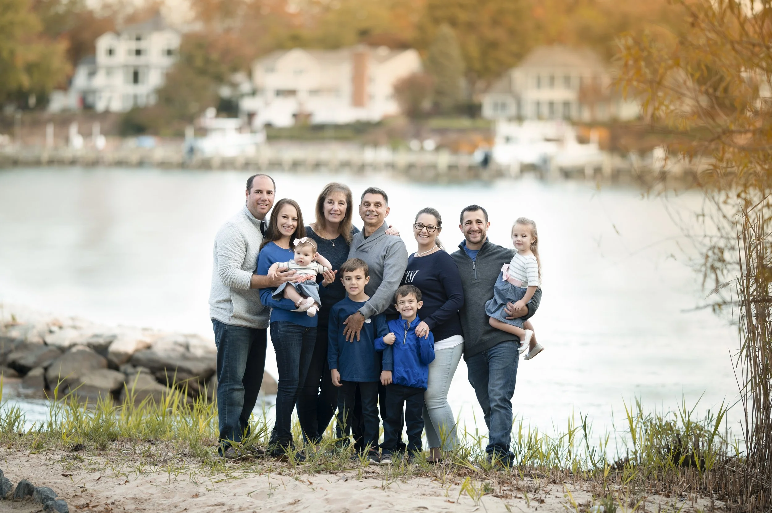 Extended family gathered outdoors by the water during a family photography session in Maryland.