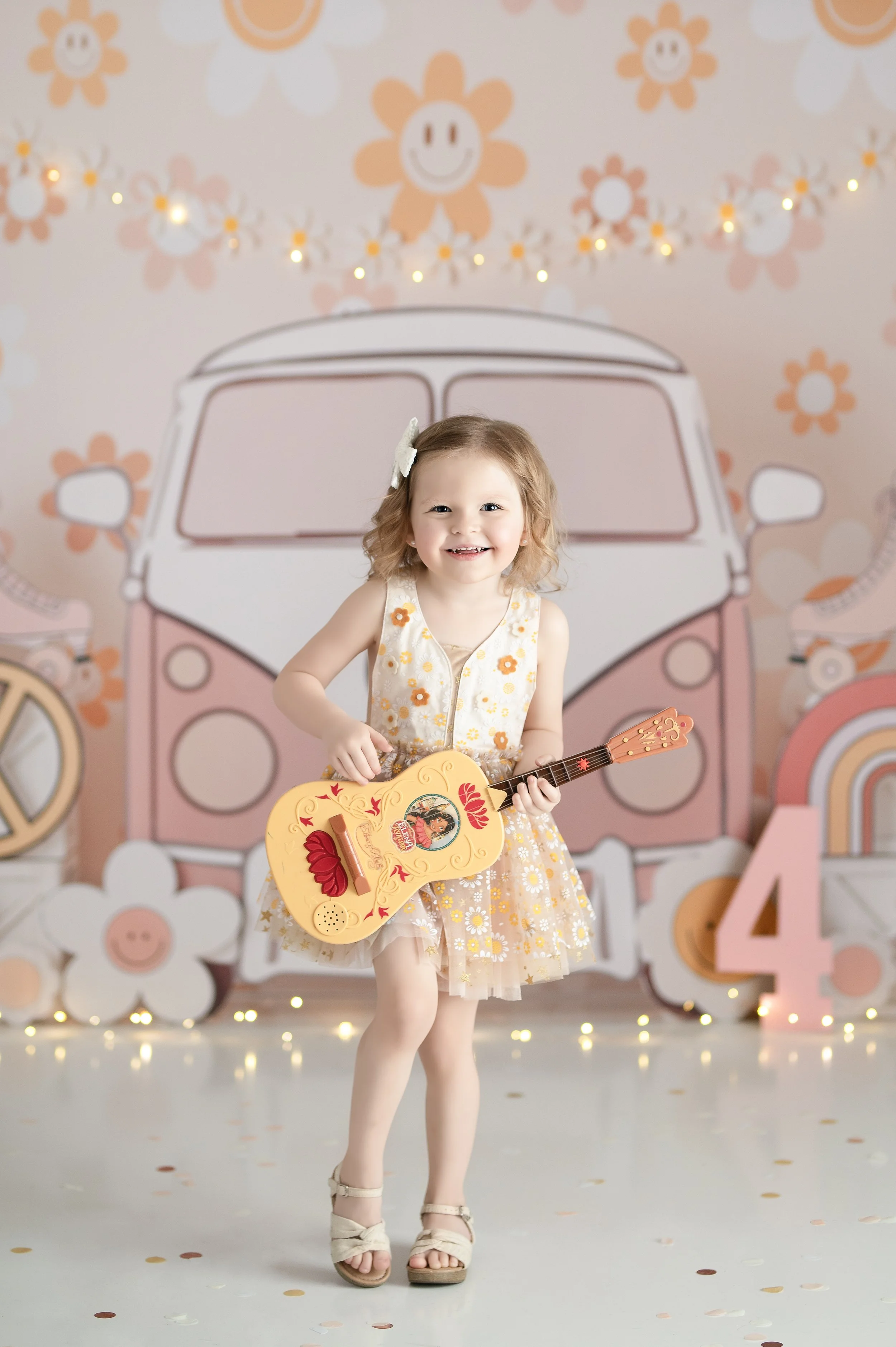 Young girl holding a toy guitar in a retro flower-themed child portrait session in Millersville, Maryland.