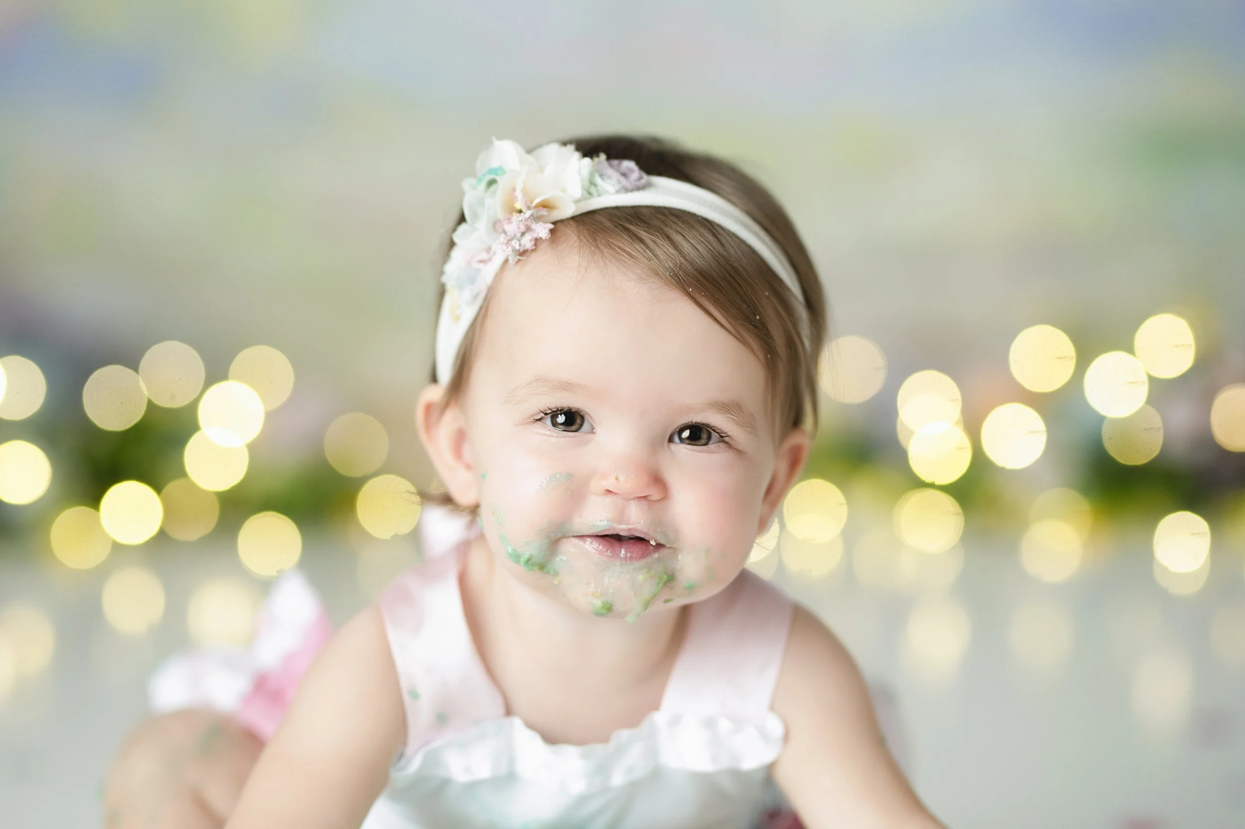 Baby girl smiling during a softly styled milestone photography session.