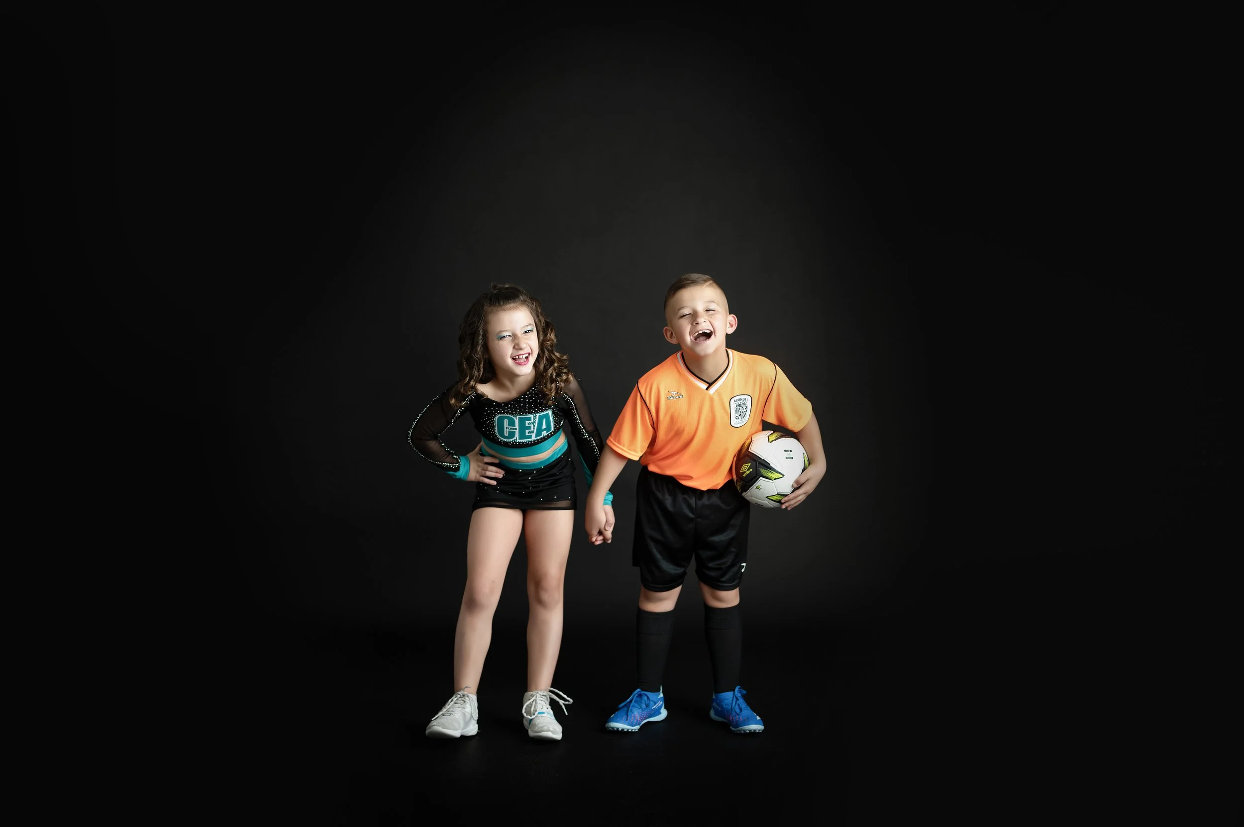 Two young athletes posing together during a small group sports portrait session.