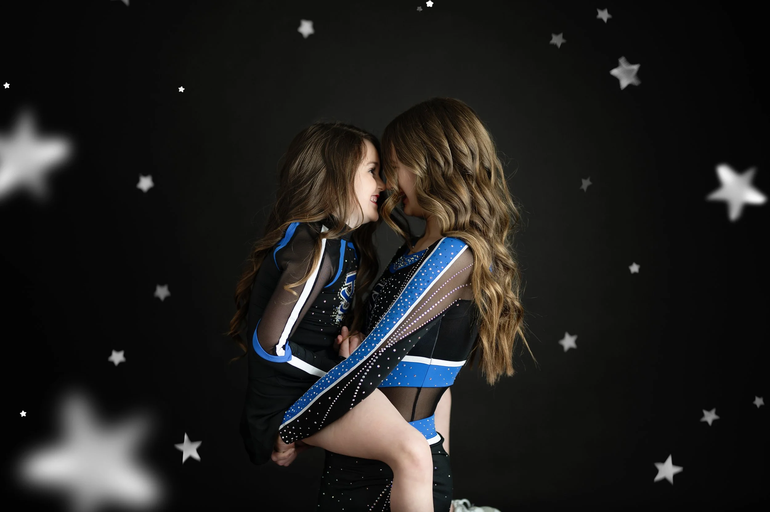 Two cheer athletes posing together during a creative studio sports portrait session.