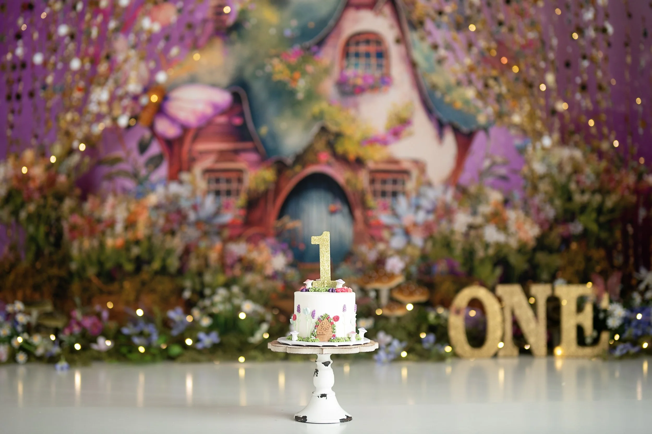 Fairy-tale inspired Cake Smash photography set featuring a colorful cottage backdrop and birthday cake.