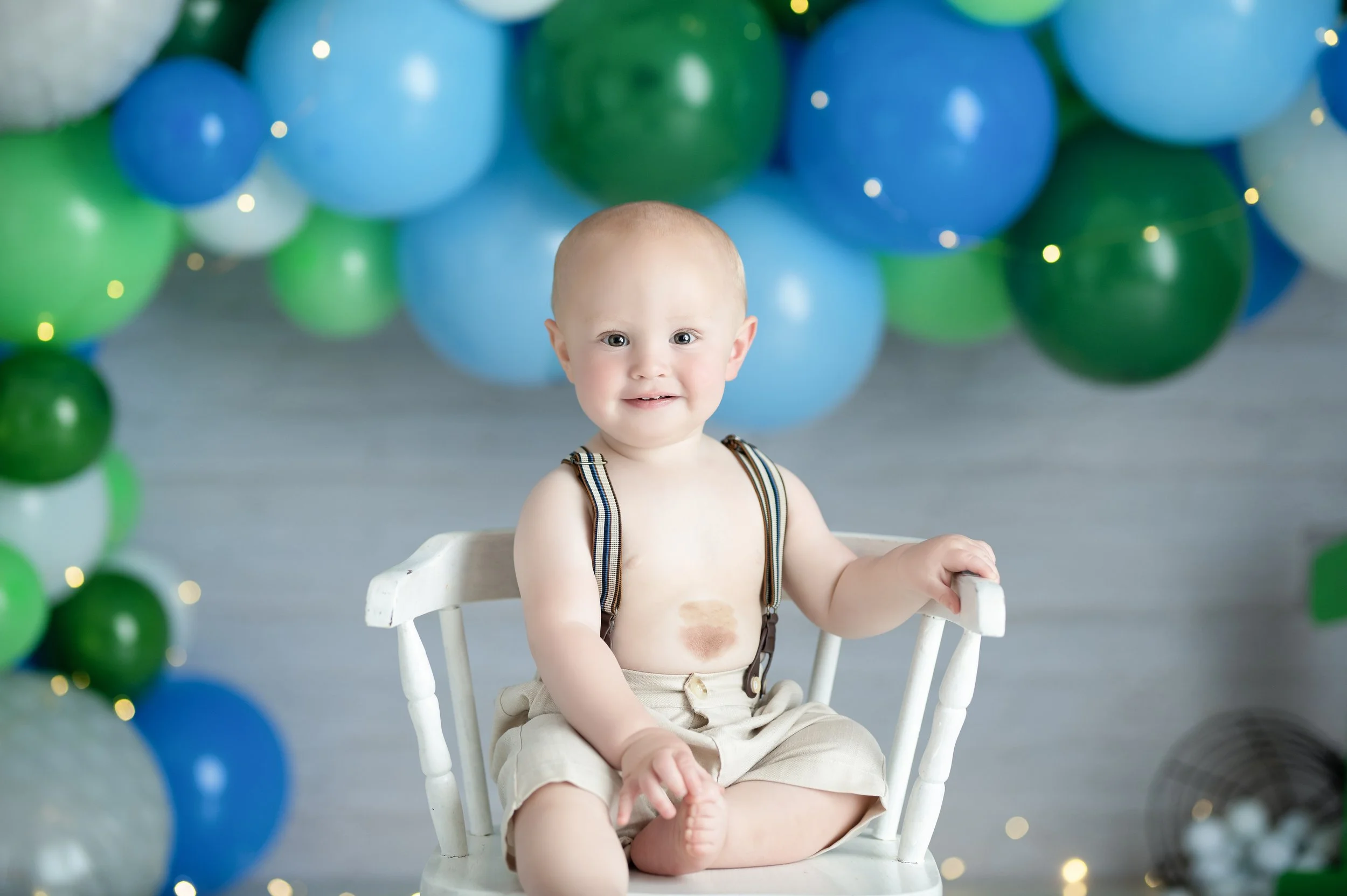 Baby boy portrait with blue and green balloons during a Classic Cake Smash session in Millersville, Maryland.