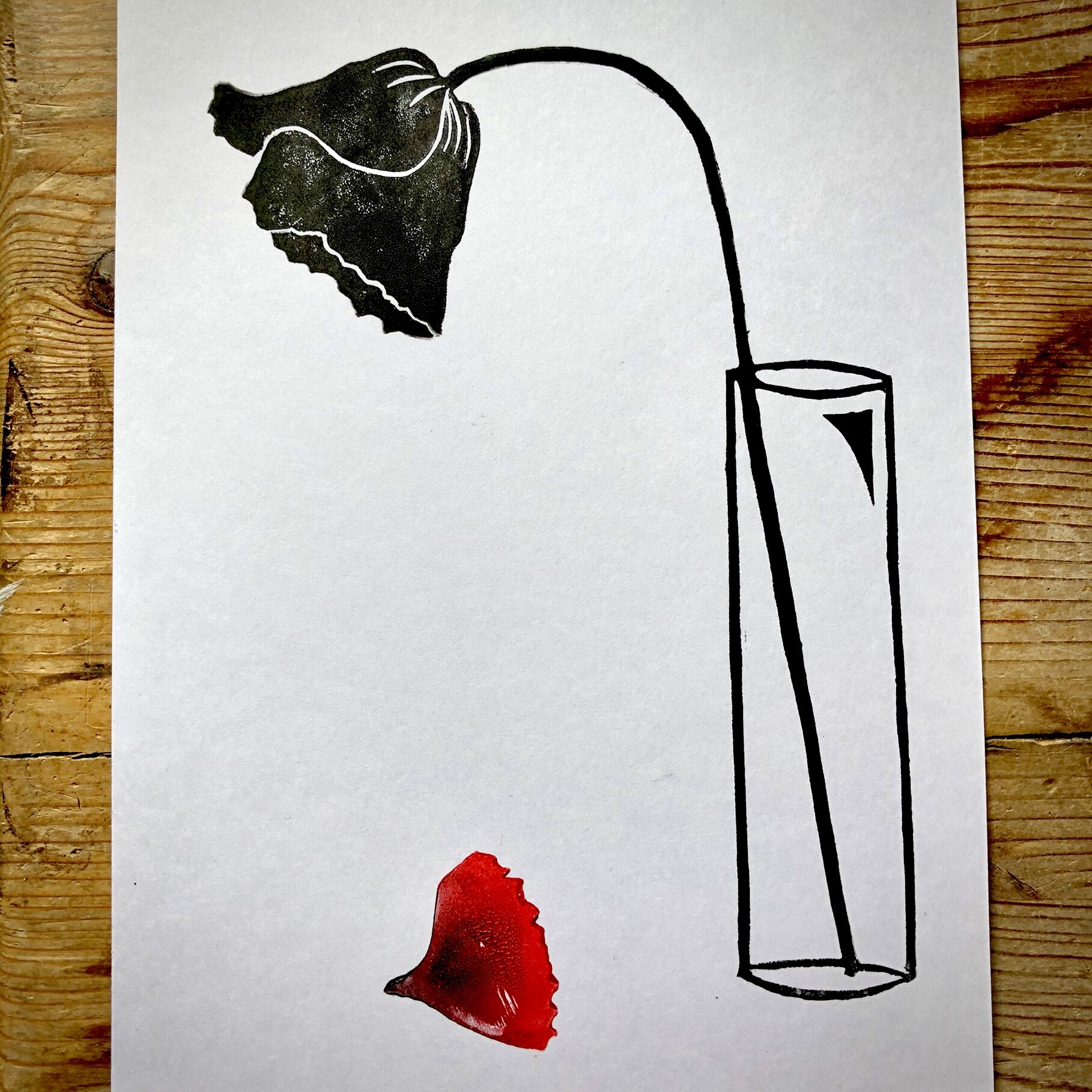 A drawing of a stapler with a black and white outline, attached to a piece of paper. The paper features a cut-out of a silhouette of the state of New Jersey and a red ink blot below it.
