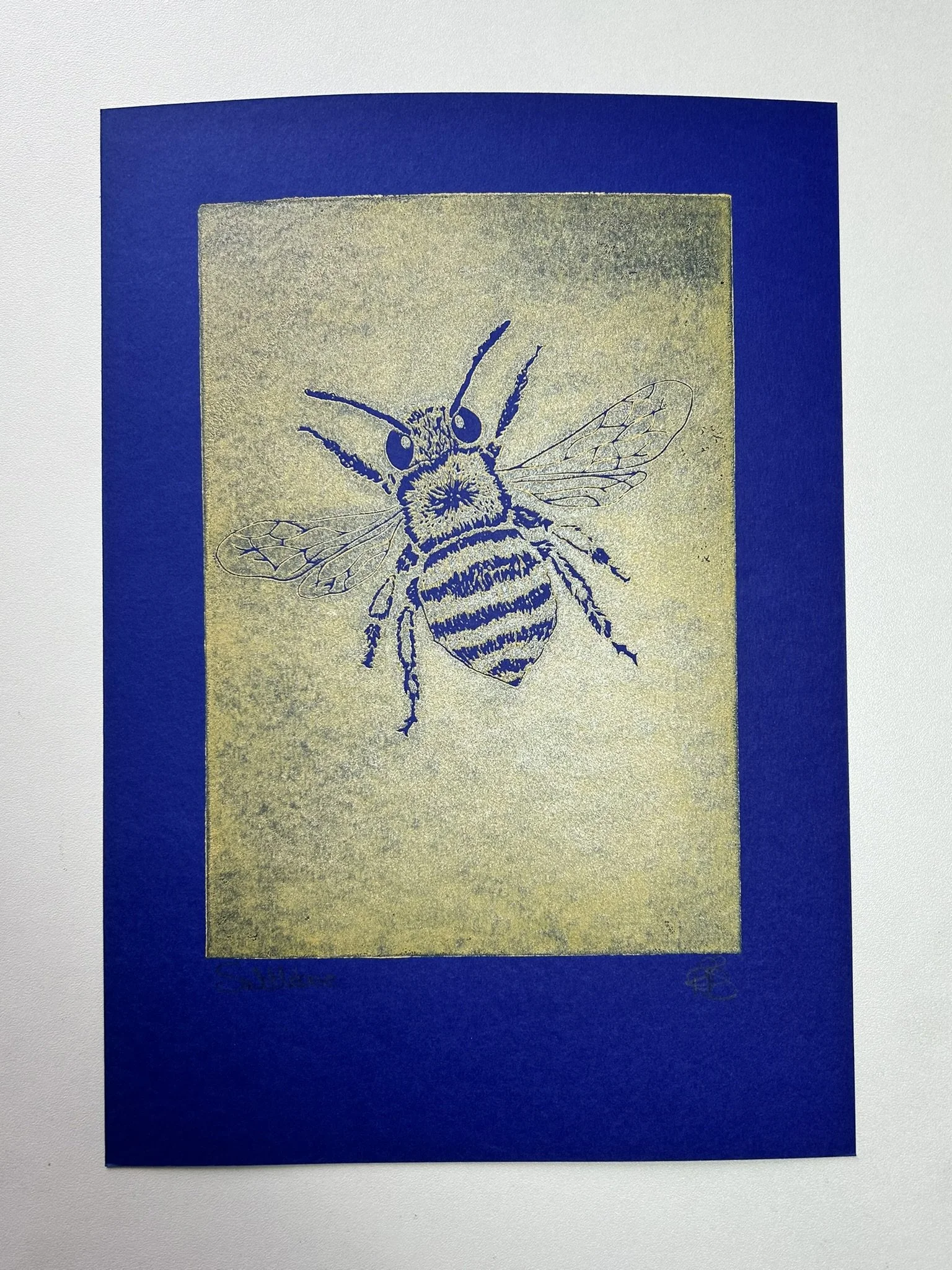 Illustration of a bee on a golden background with a blue border.