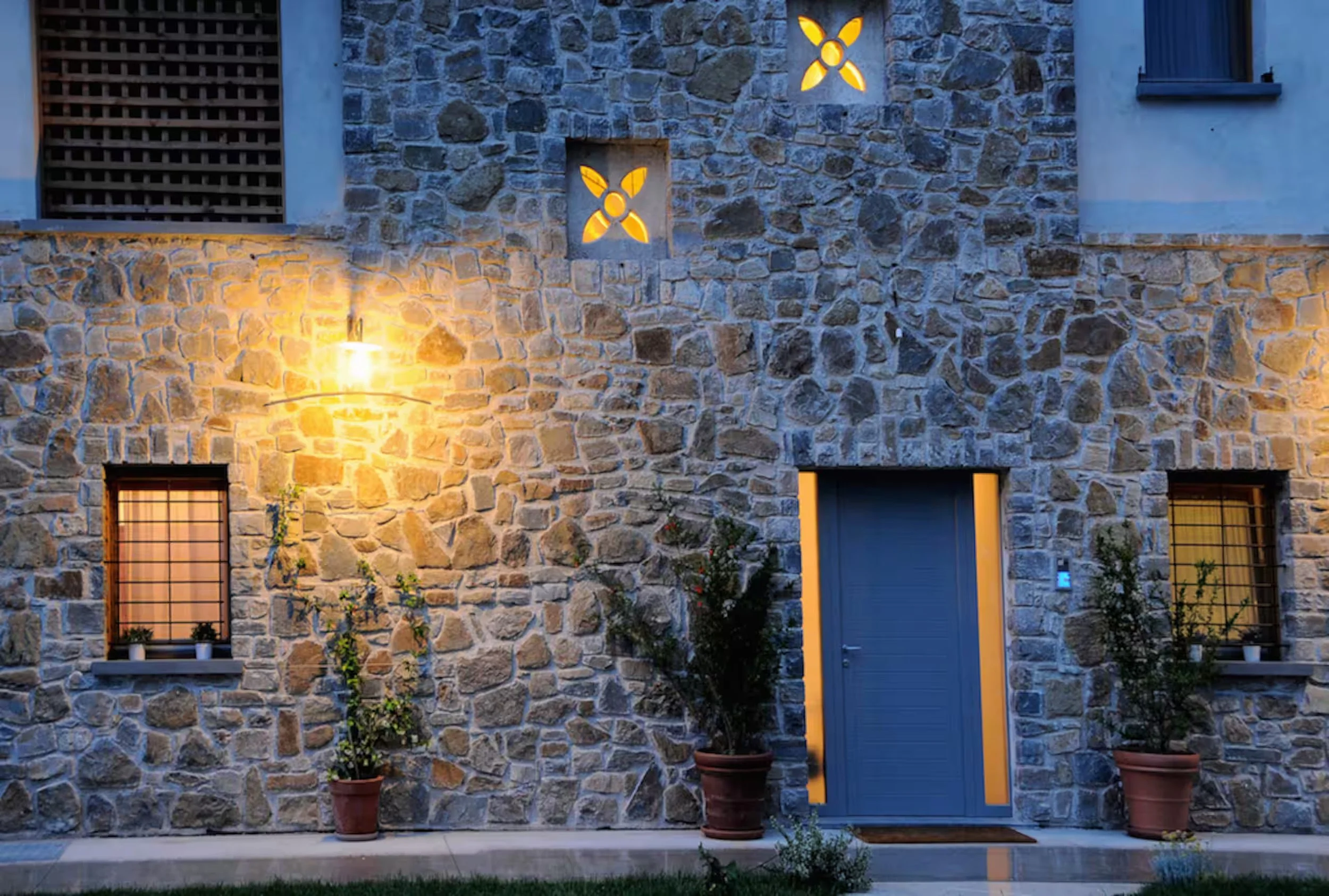 The stone facade of the relais lit up in the evening