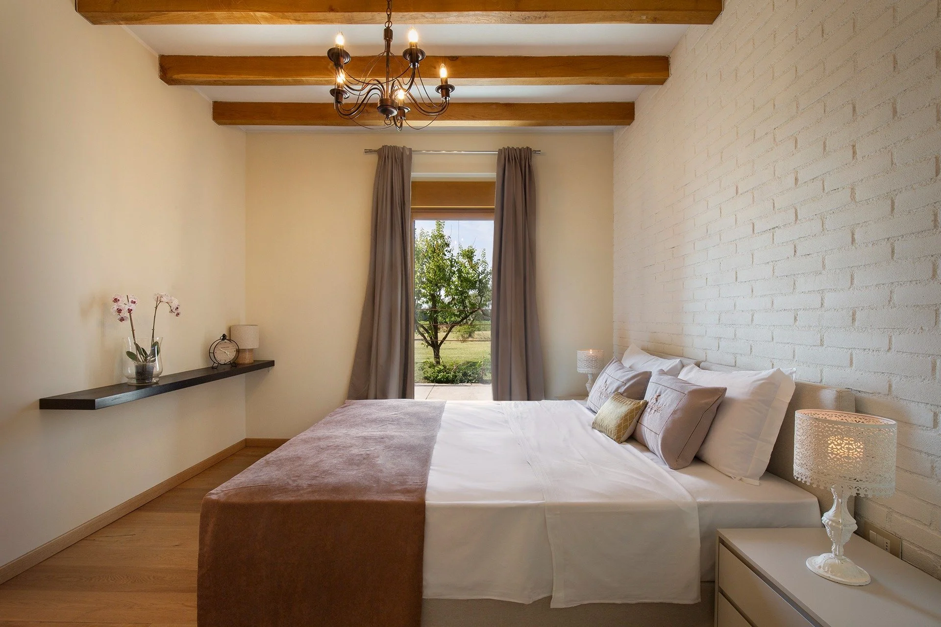 Double room with exposed beams and a window onto the greenery