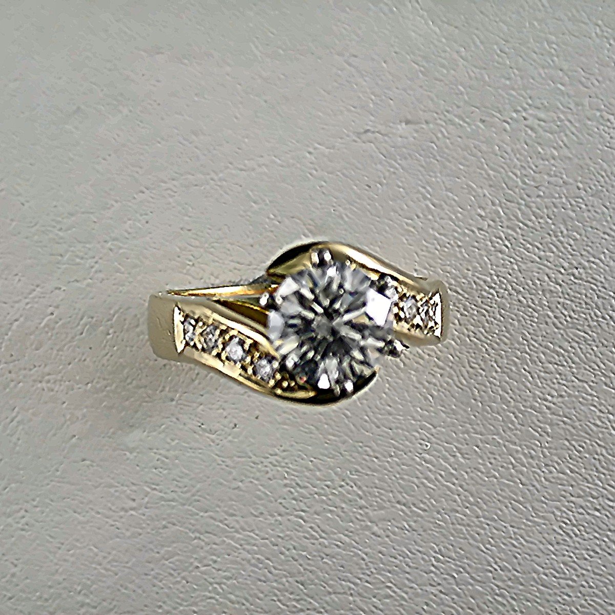 Gold ring with a large central diamond surrounded by smaller diamonds