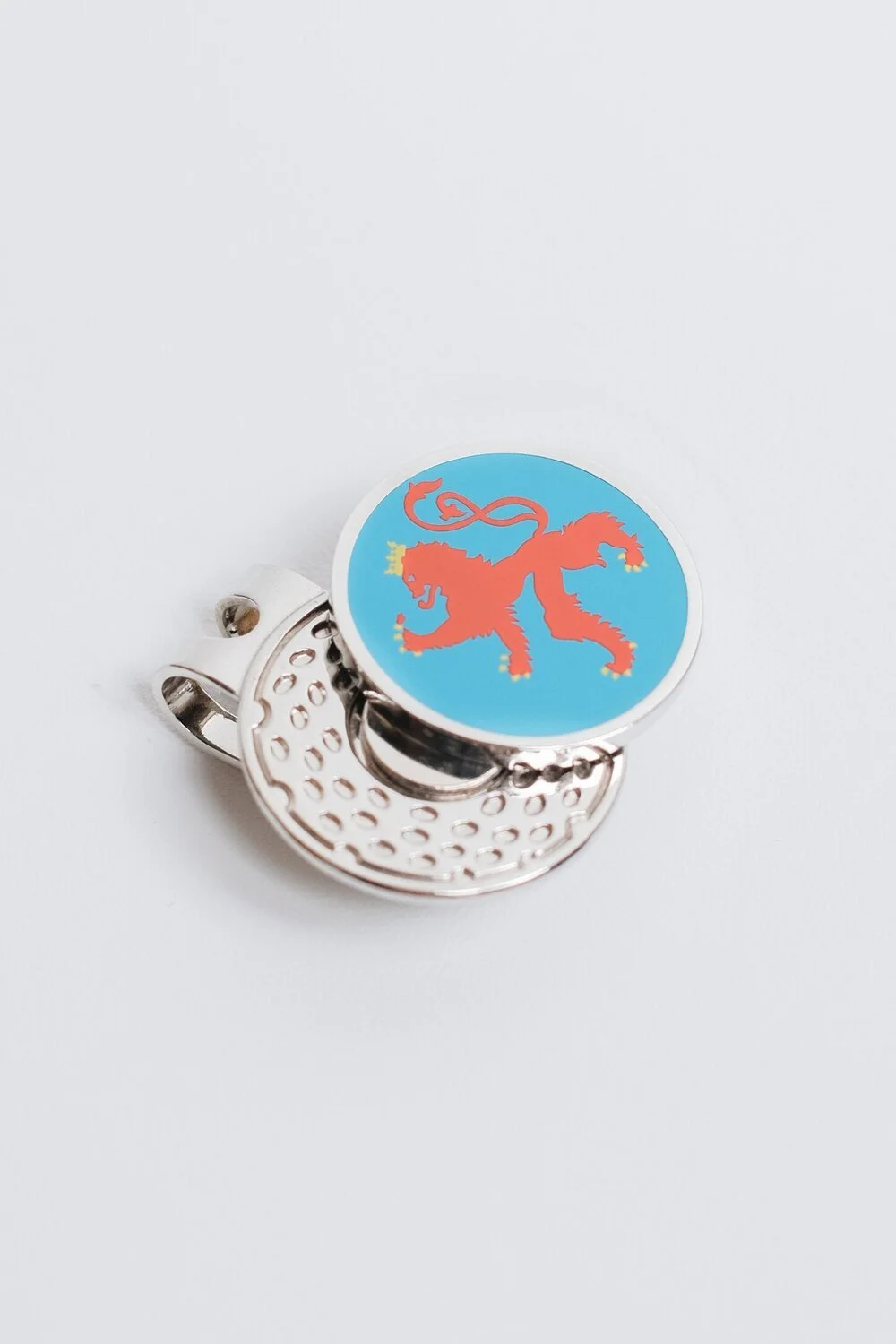 Magnetic hat clip golf ball marker with a heraldic lion crest on a golf-ball textured clip