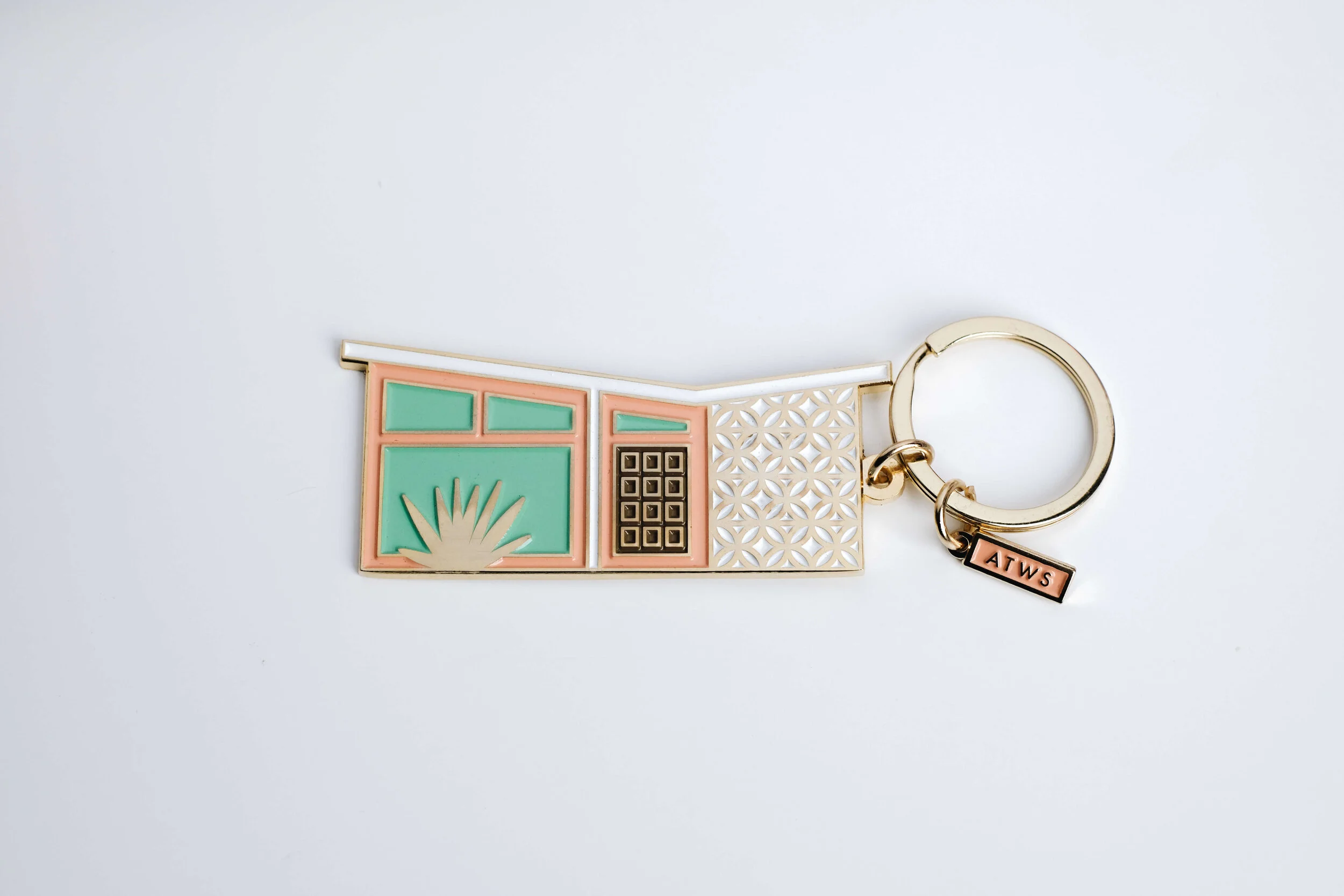 Soft enamel keychain shaped like a shophouse window facade, with a gold key ring and branded tag