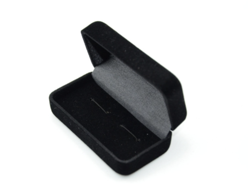 Cufflinks in an open black velvet jewellery box with a hinged lid