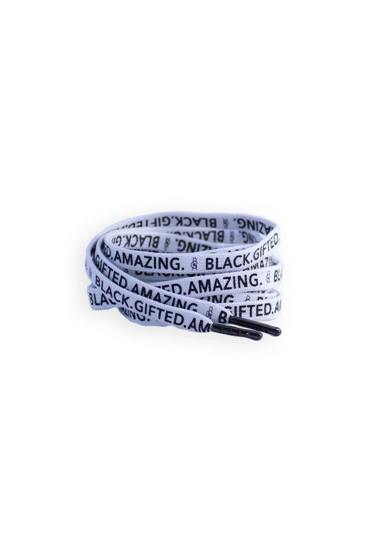 Coiled flat white shoelaces printed with a repeating slogan in black