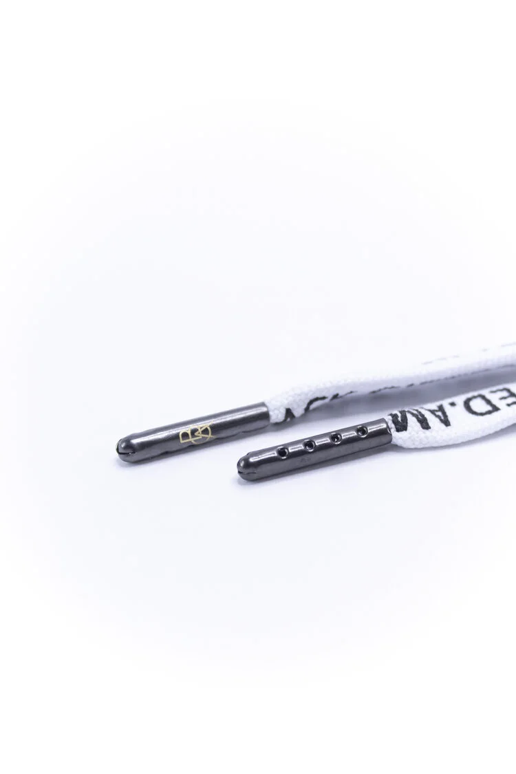 Gunmetal plated metal aglets in bullet and cylindrical styles on white printed shoelaces