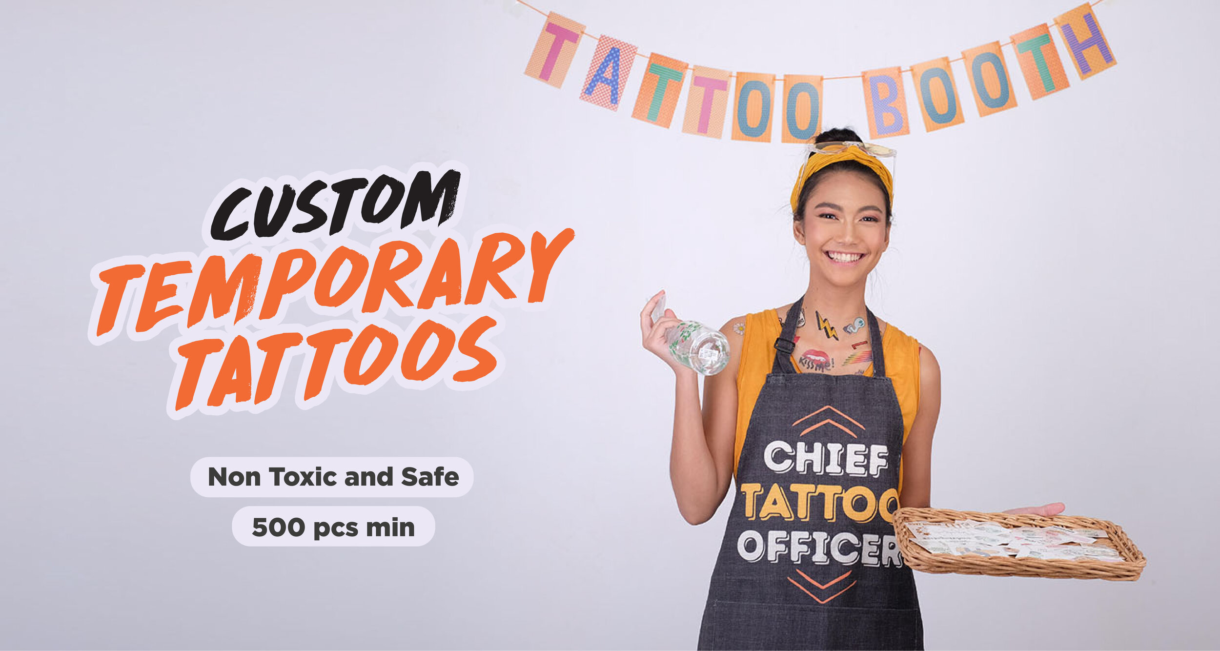 Event host in a Chief Tattoo Officer apron running a tattoo bar with custom temporary tattoos