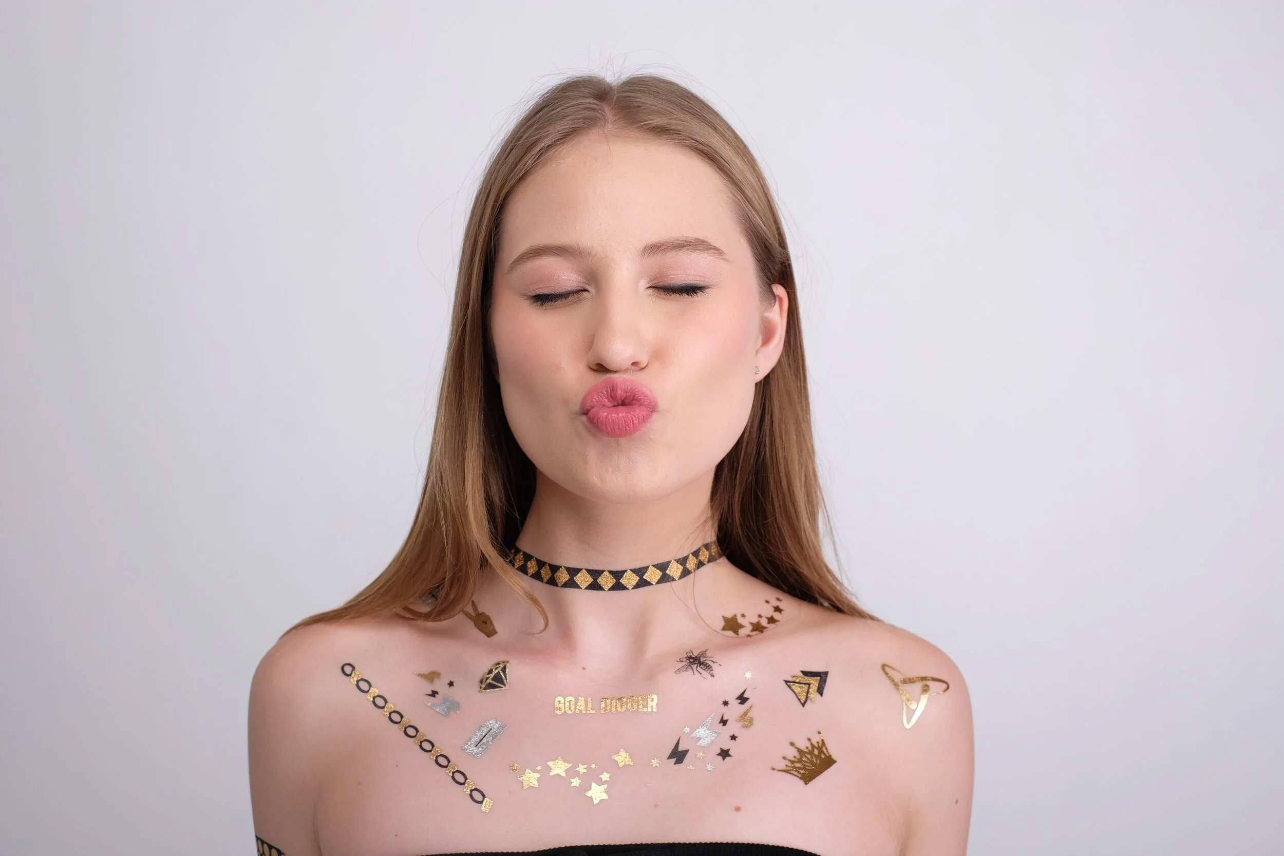 Metallic gold foil temporary tattoos worn across the collarbone and shoulders like fine jewellery