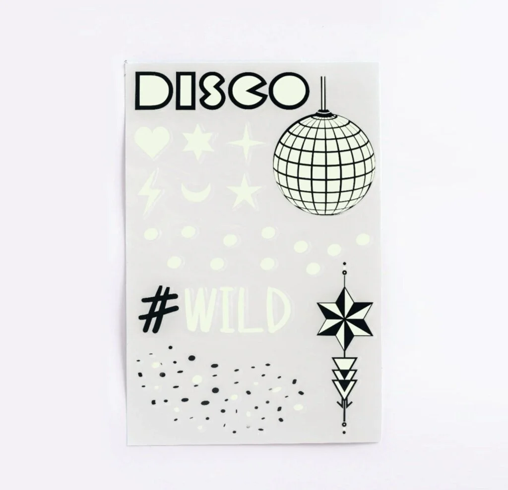 Glow in the dark temporary tattoo sheet printed in fluorescent ink with a disco ball, stars and moon
