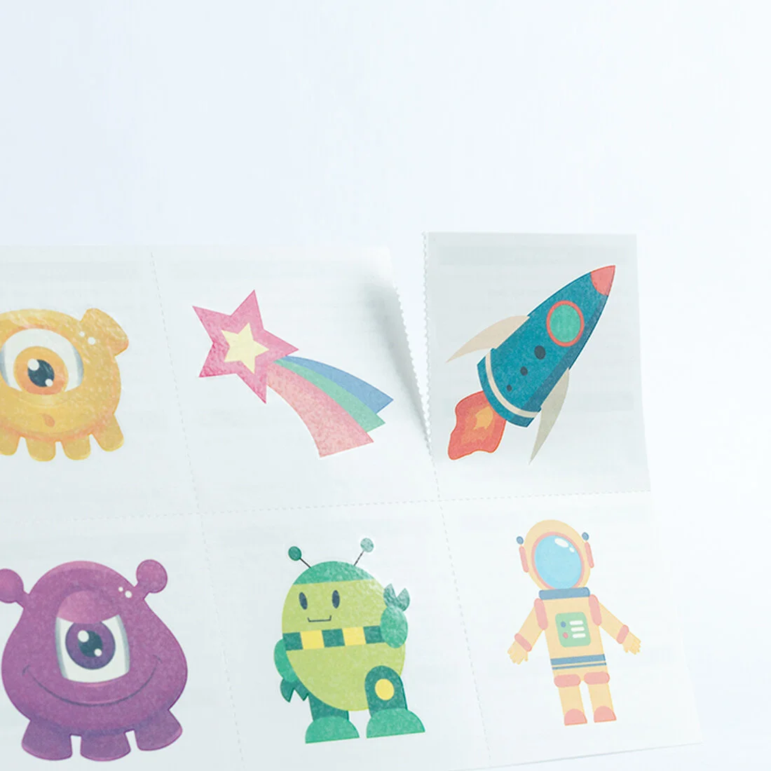 Perforated temporary tattoo sheet with tear lines between different designs