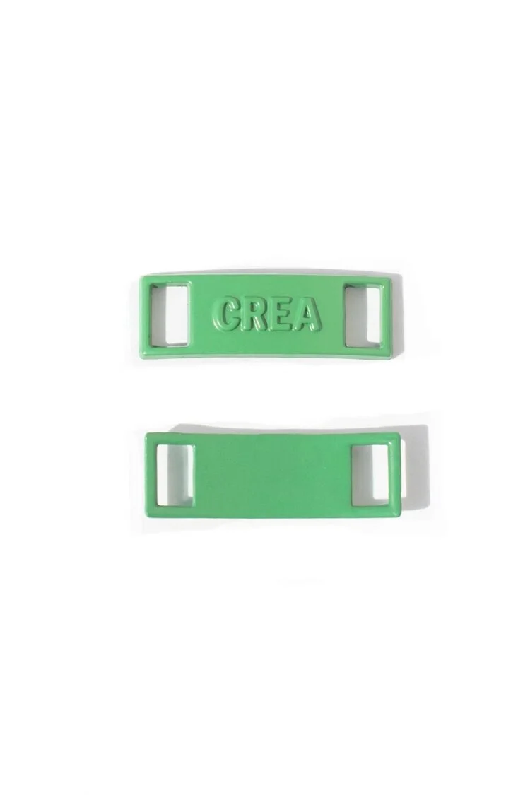 Green shoe dubrae with raised engraved lettering standing proud of the surface