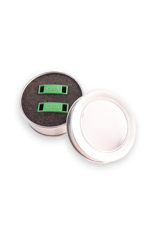 Two green shoe dubraes seated in a moulded foam insert inside a premium tin box