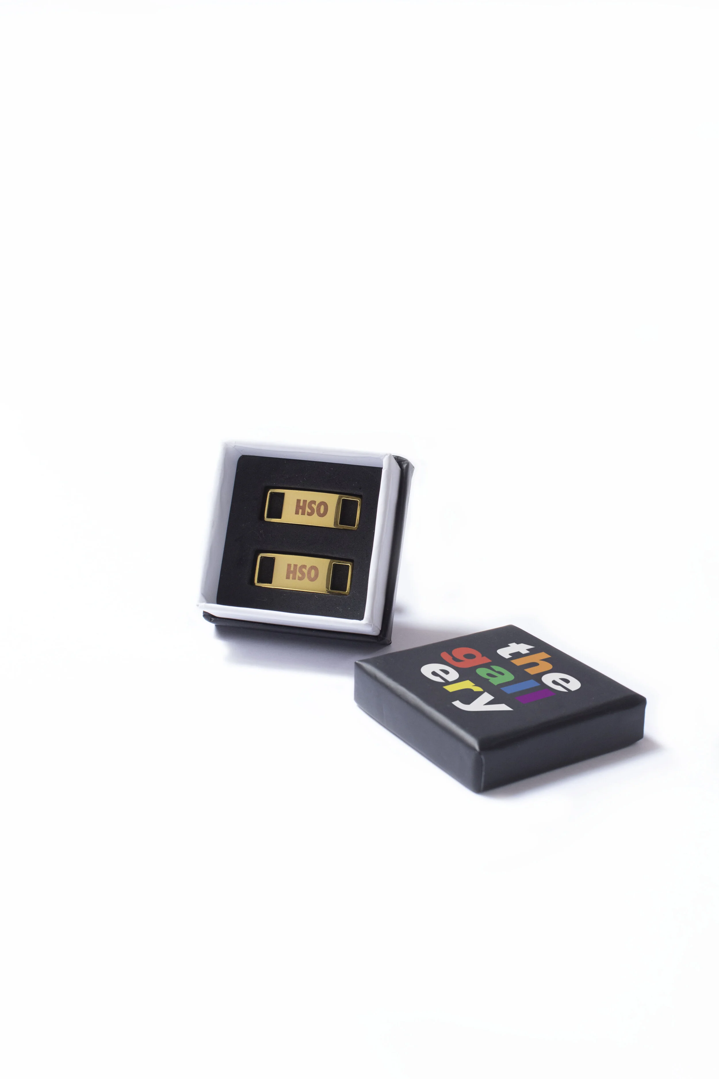 Two gold shoe dubraes in a moulded foam insert inside a designer cardboard box with printed sleeve
